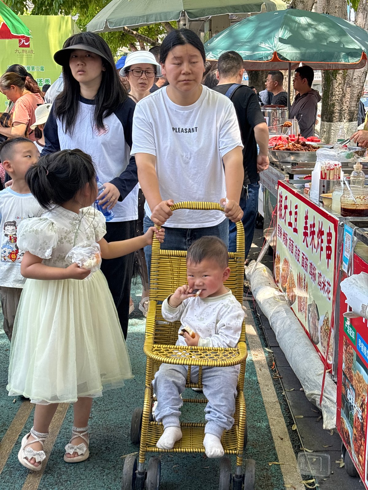 Family gathers outdoors in Jiulongpo District, baby feeds in chair