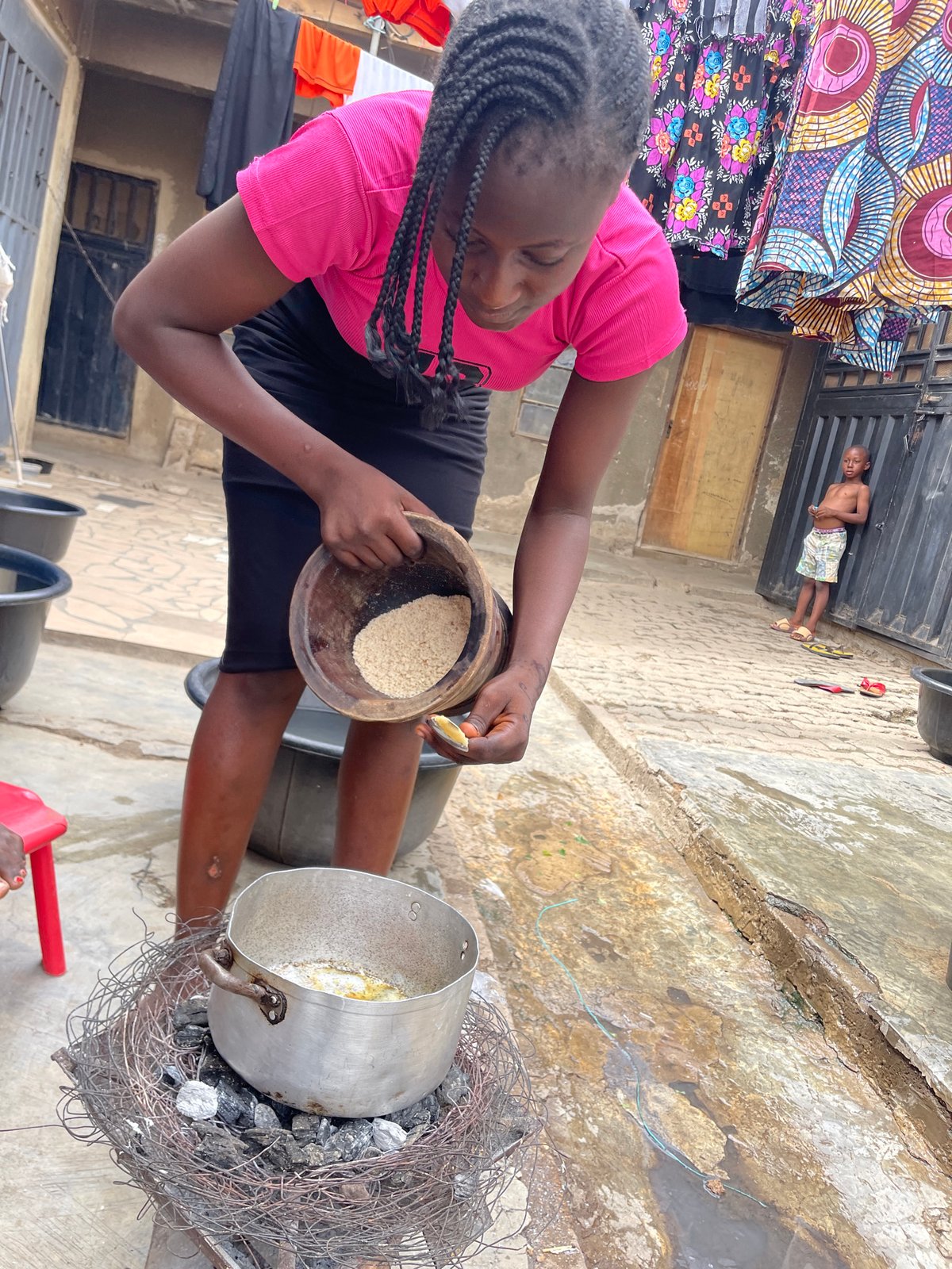 Women prepare food outdoors in Nyanya, Nigeria
