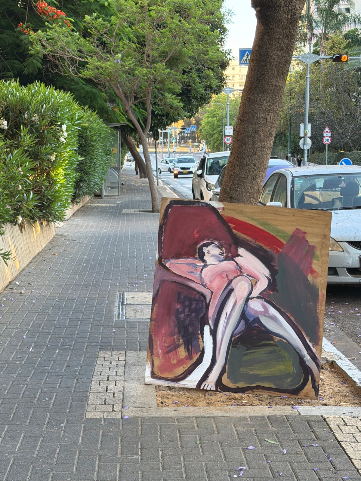 Large reclining figure painting rests on a Tel Aviv sidewalk
