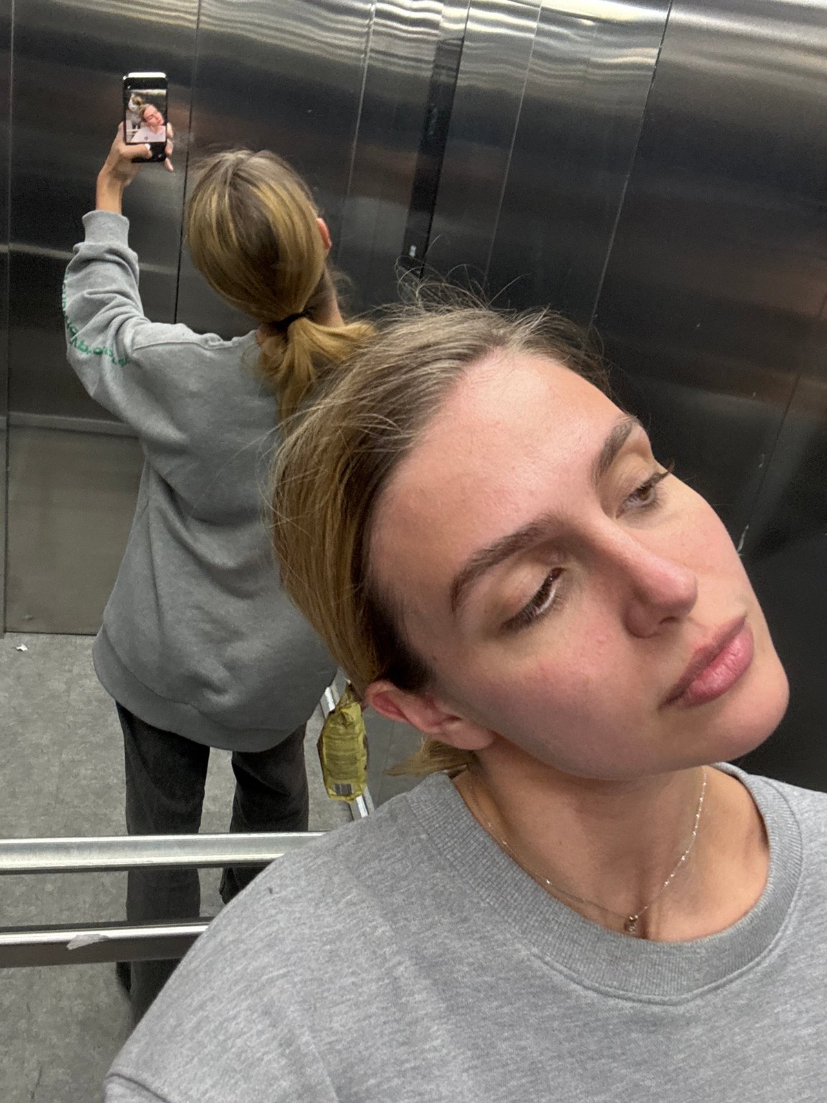 Woman captures selfie in reflective surface at undisclosed location