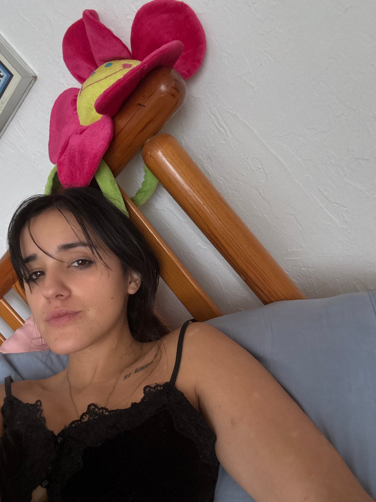 Woman rests in bed with decorative pillow, Mexico City