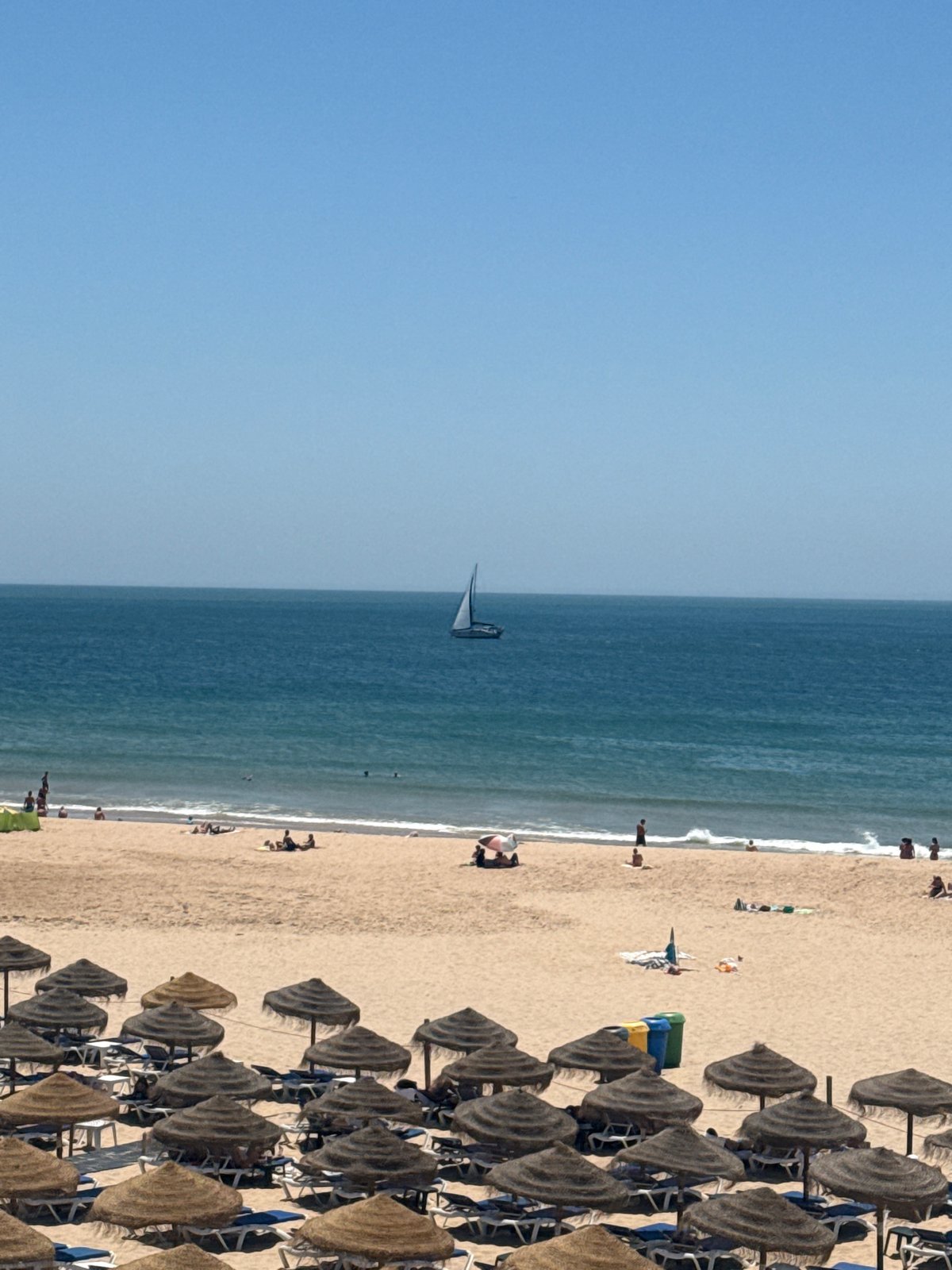 Sunny midday at a packed Cascais beach, Atlantic coast