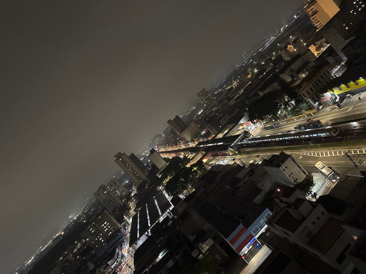 Late-night beer drinking overlooking São Paulo cityscape captured