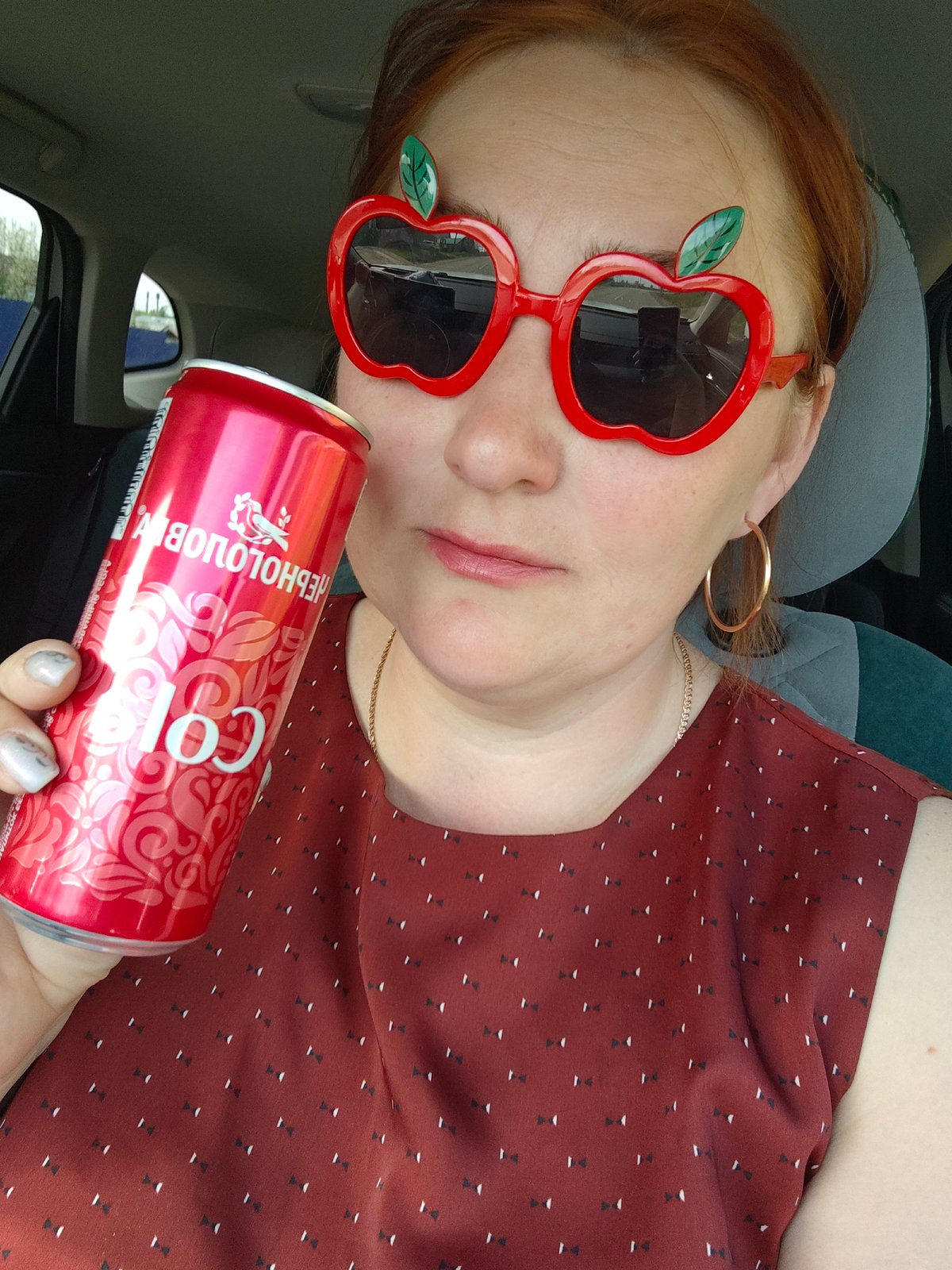 Woman sports apple sunglasses while drinking cola in Russia