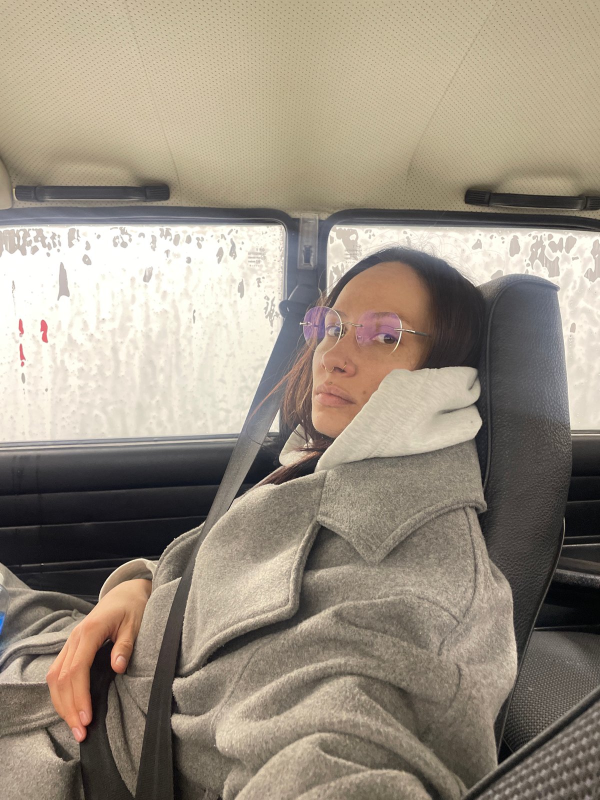 Person in gray coat observed seated in vehicle, Izhevsk