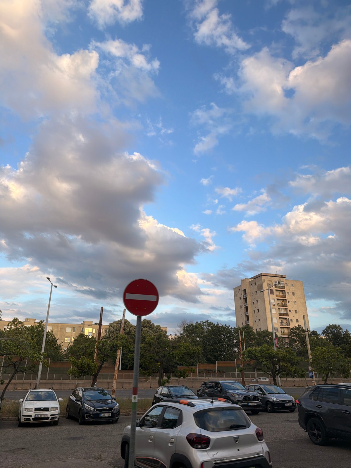 Budapest transit street with graffiti, buses, and shifting skies