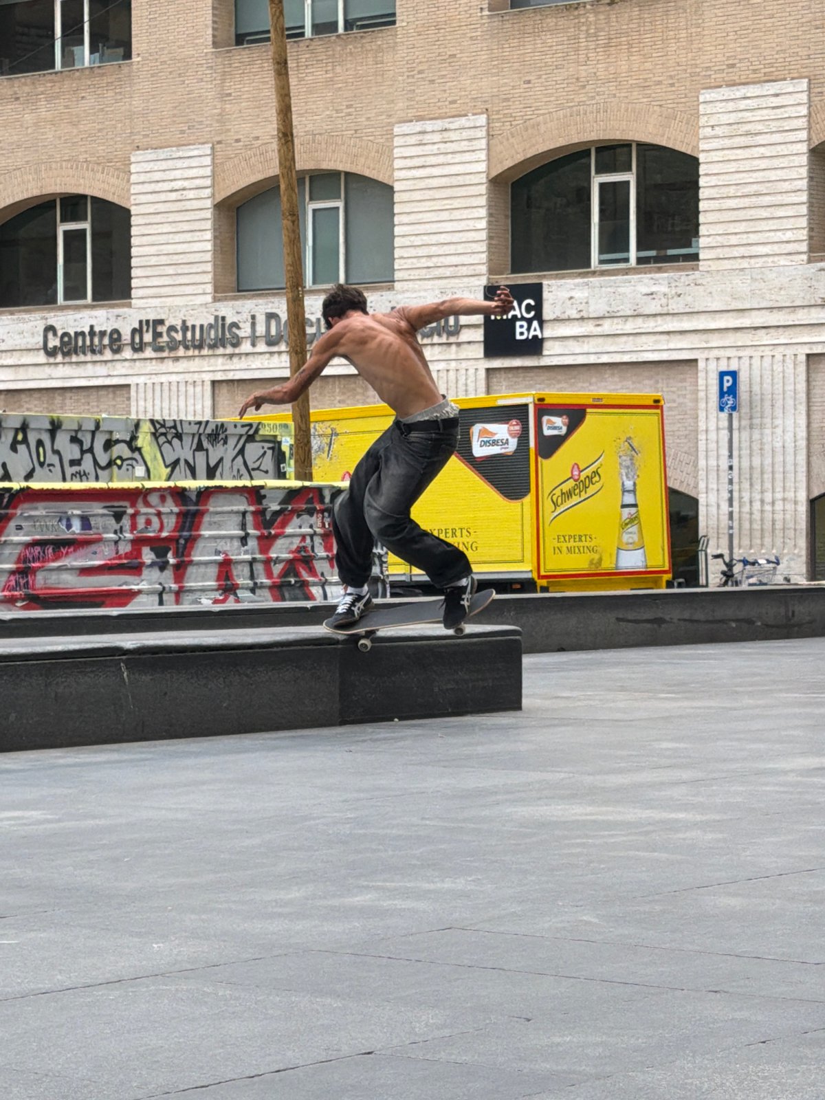Skateboarders perform tricks at Barcelona plaza during midday session