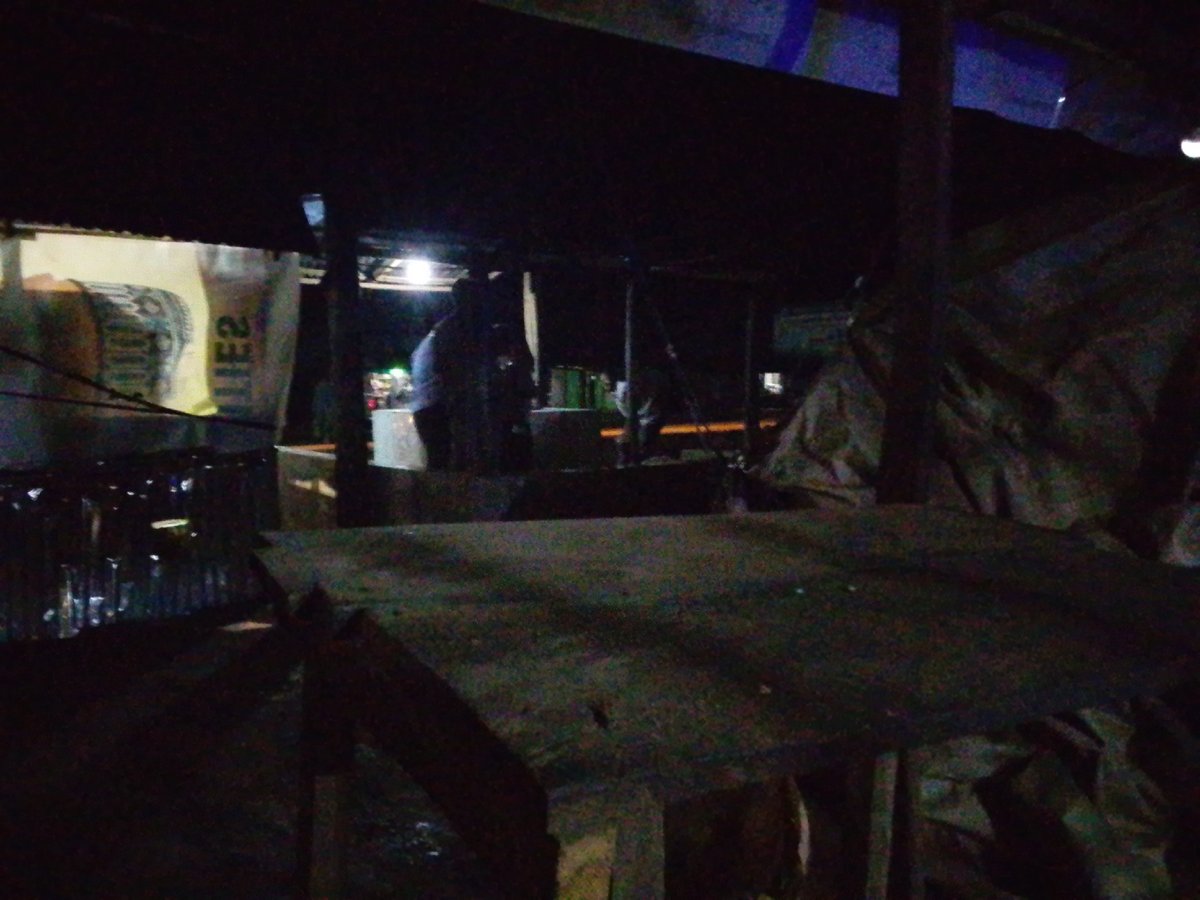 Night market scene, rough wooden table, dim artificial light