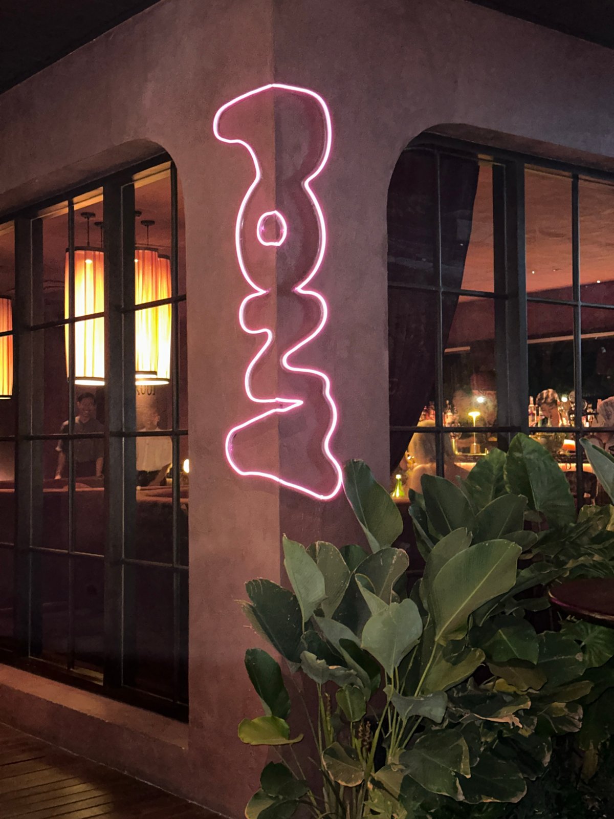 Modern restaurant entrance with pink neon sign, North Kuta