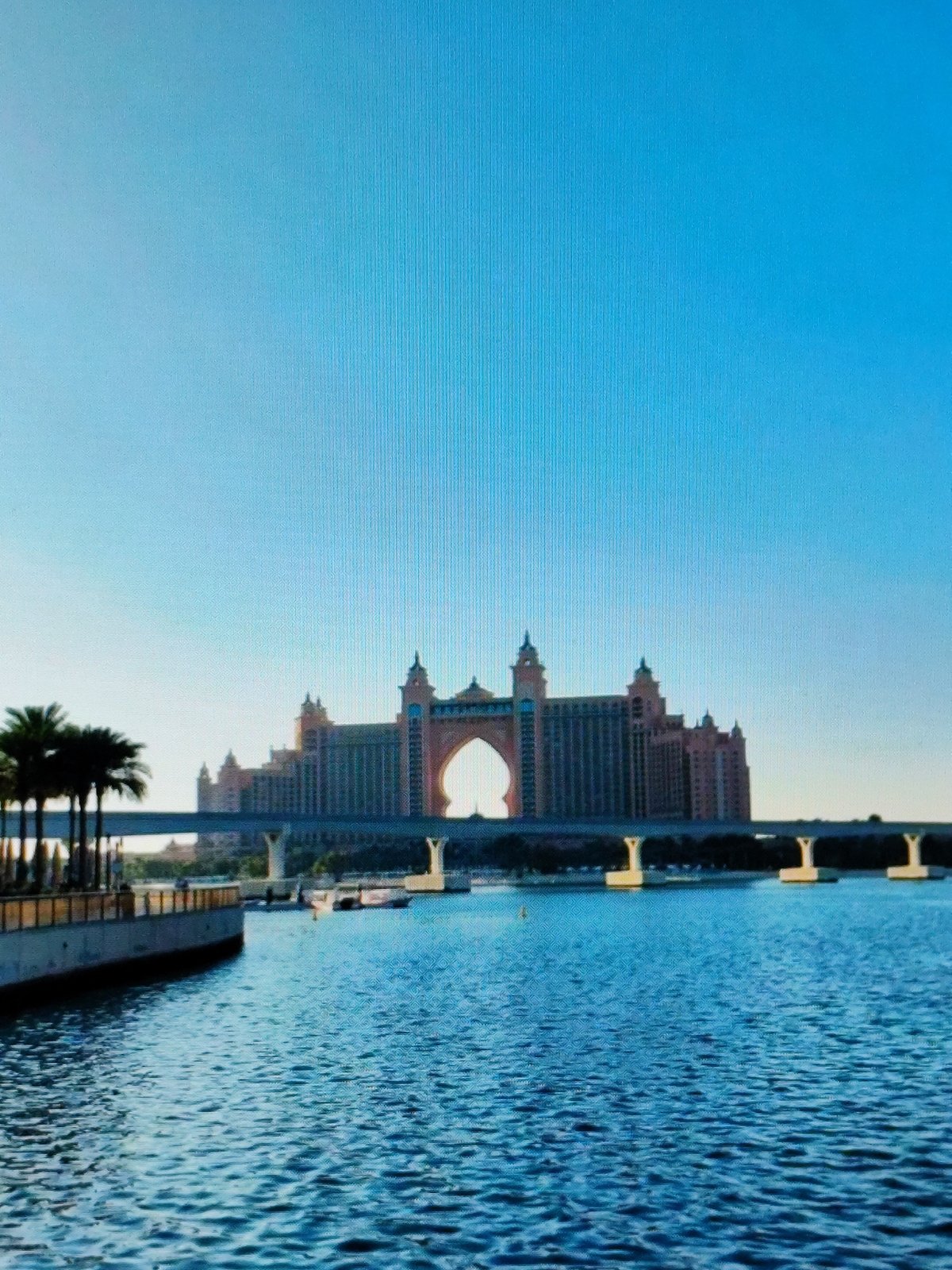 Ornate pink waterfront hotel with a bold arched facade