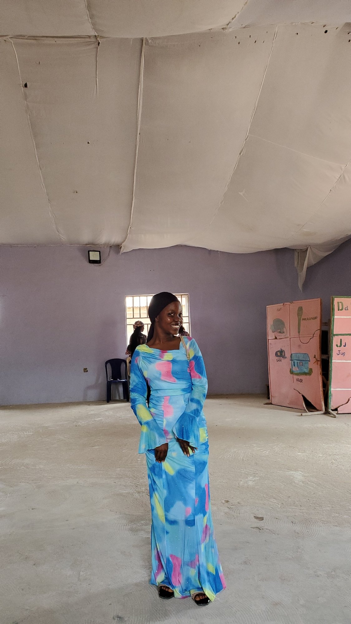 Indoor gathering in Jalingo community hall, colorful dress on display