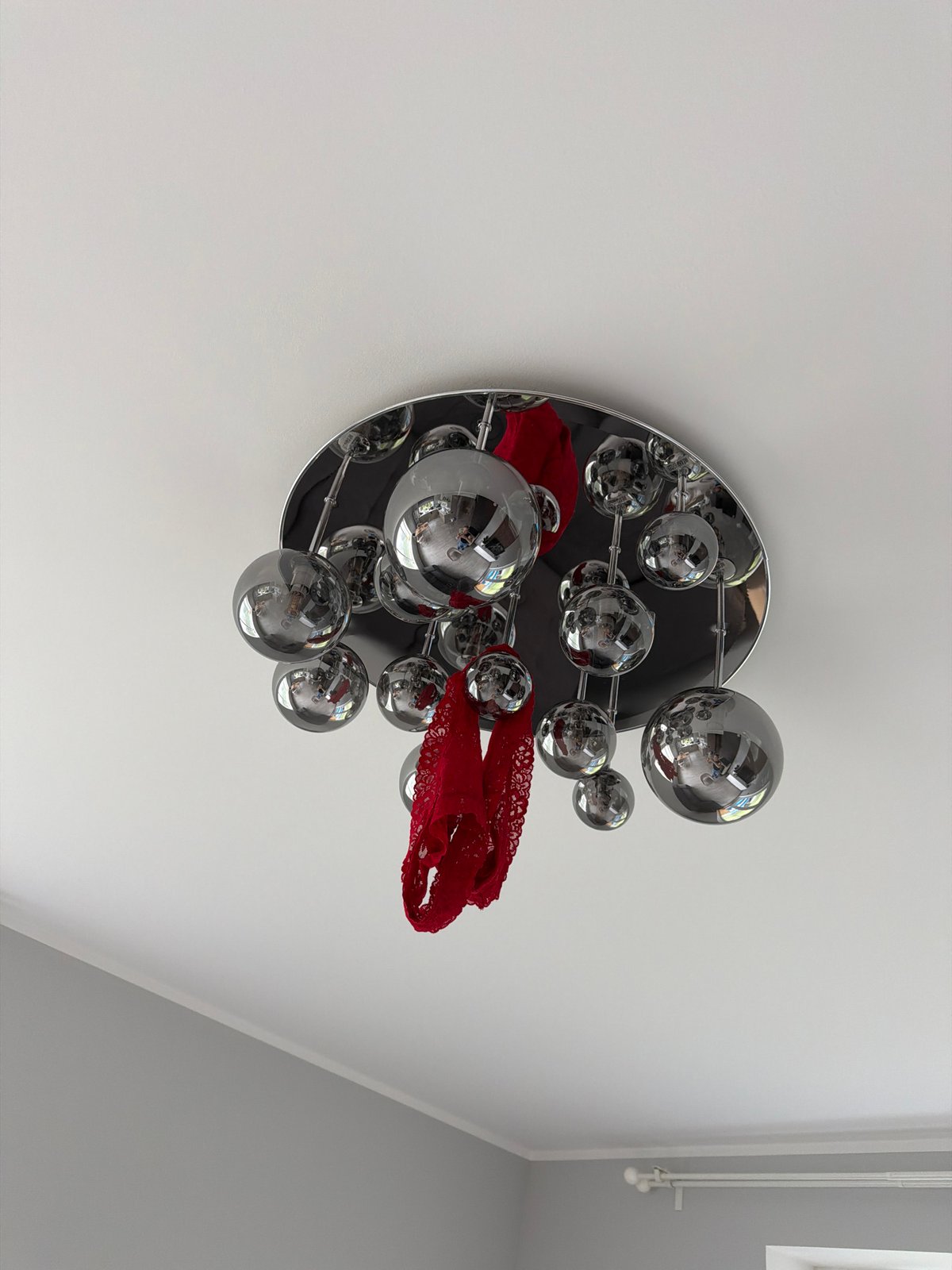 Red lace adorns chrome light fixture in Latvia