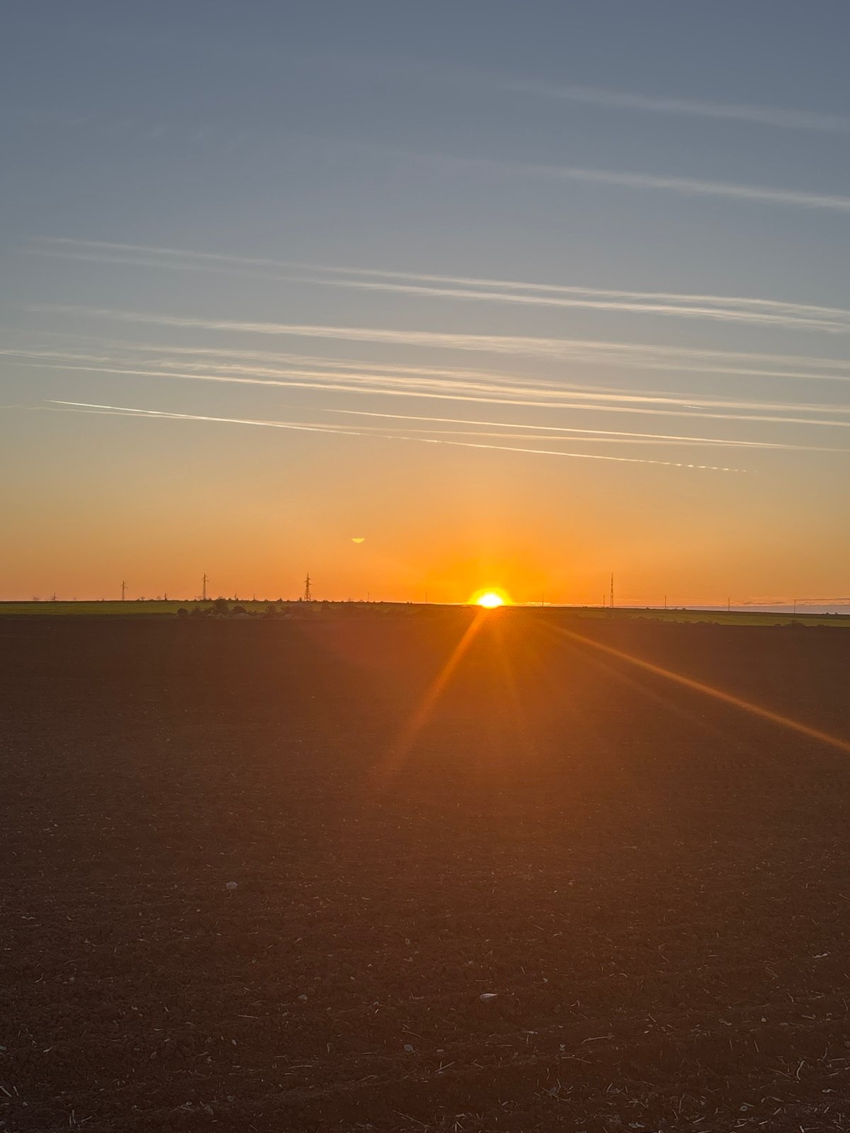 Split-sky sunset captured in Bulgarian village with contrails
