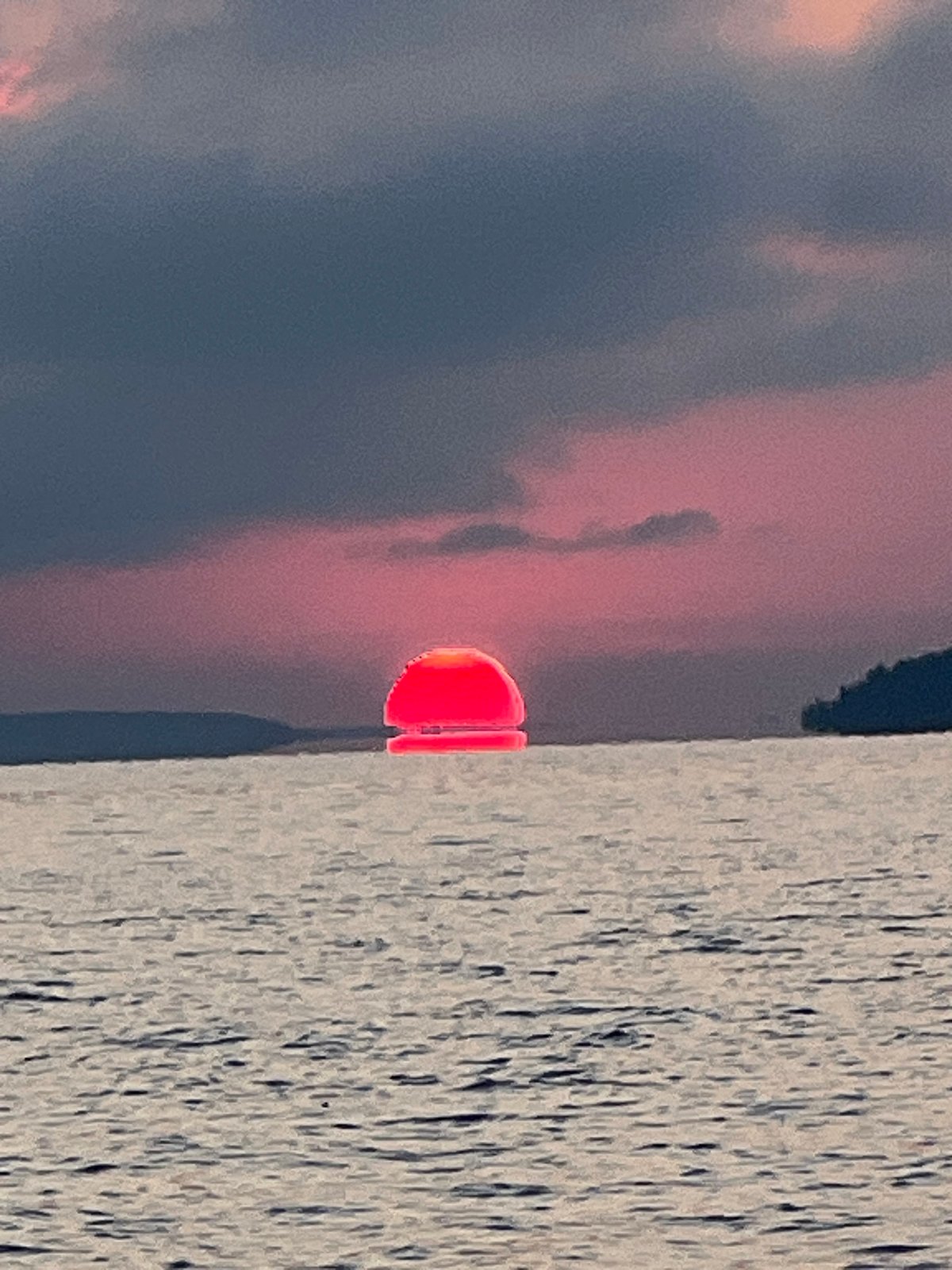 Vivid pink-orange sunset over the water near Novopichugovo, Russia
