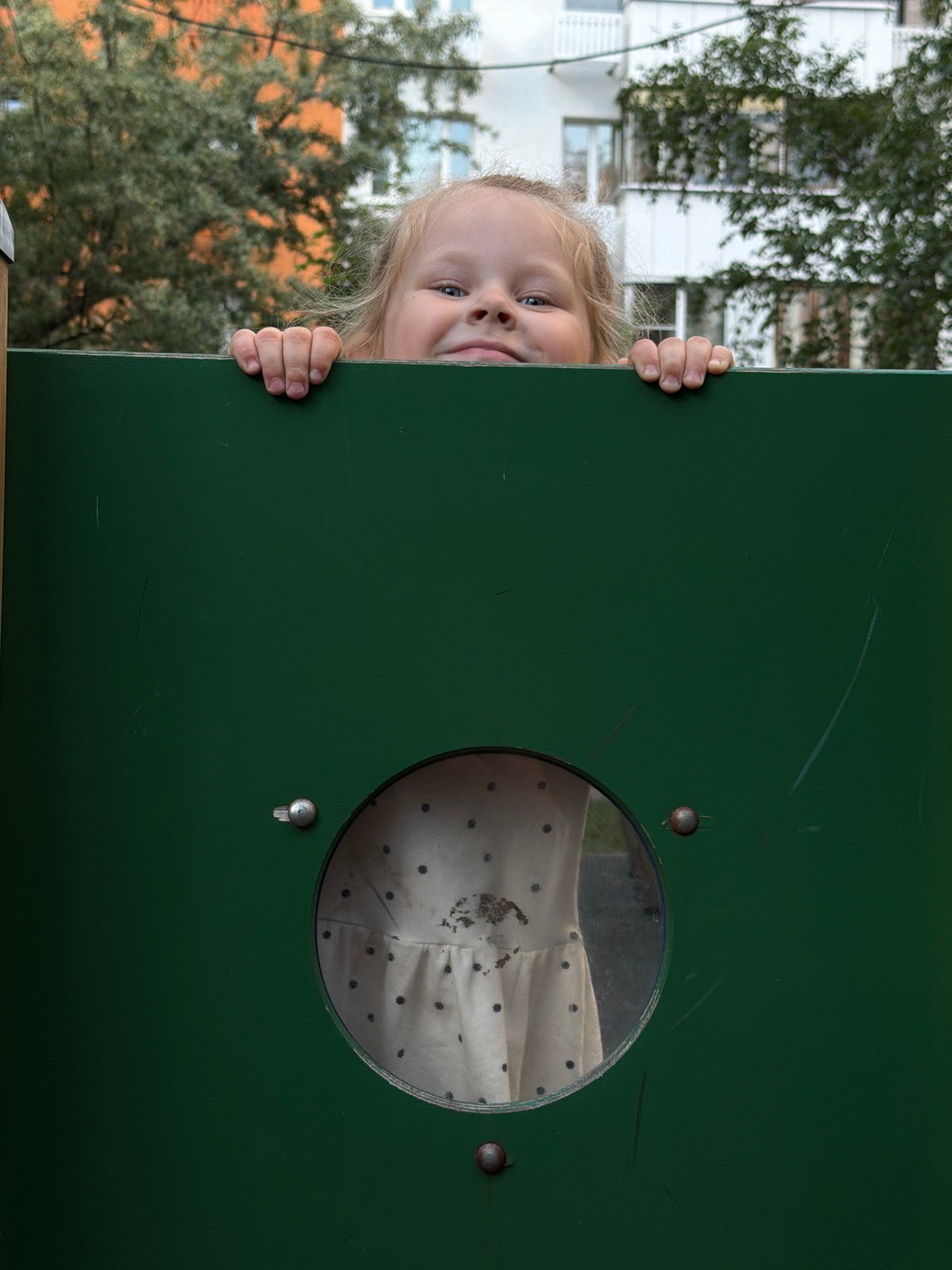 Child plays at Moscow playground equipment, climbs and cleans