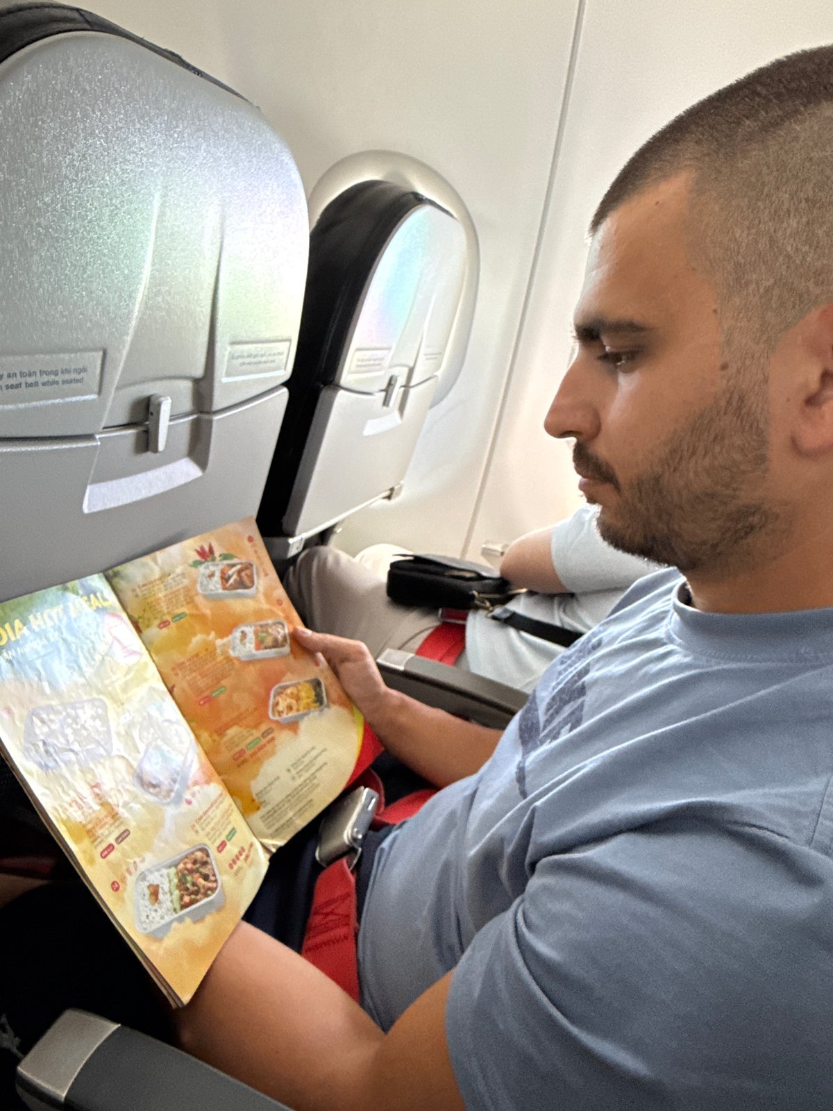 Vietjet passengers browse meal menus during Malaysia transit flight