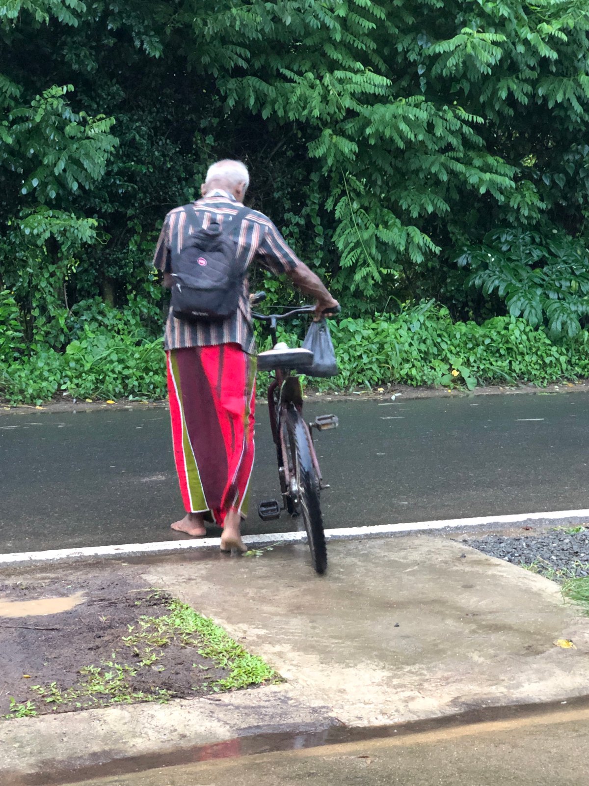Cyclists moving through wet roads in Kodagoda after rain