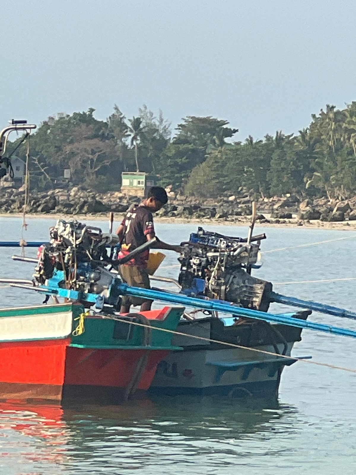 Boats, beaches, and golden-hour light on calm coastal water