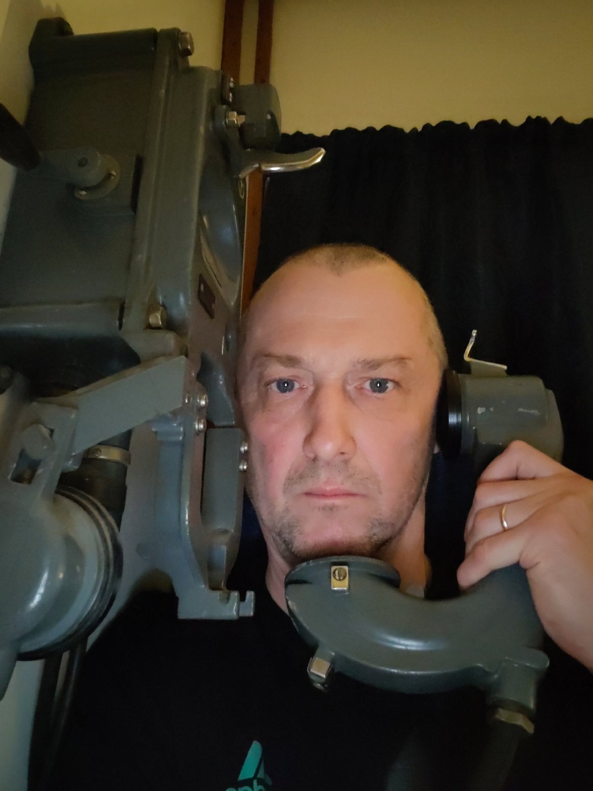 Man photographs vintage equipment aboard ship during evening hours