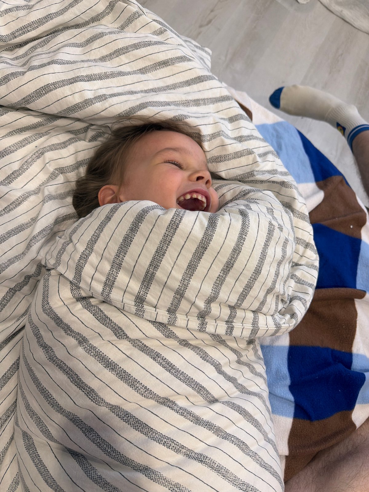 Family shares playful moment on bed in Chaikovsky