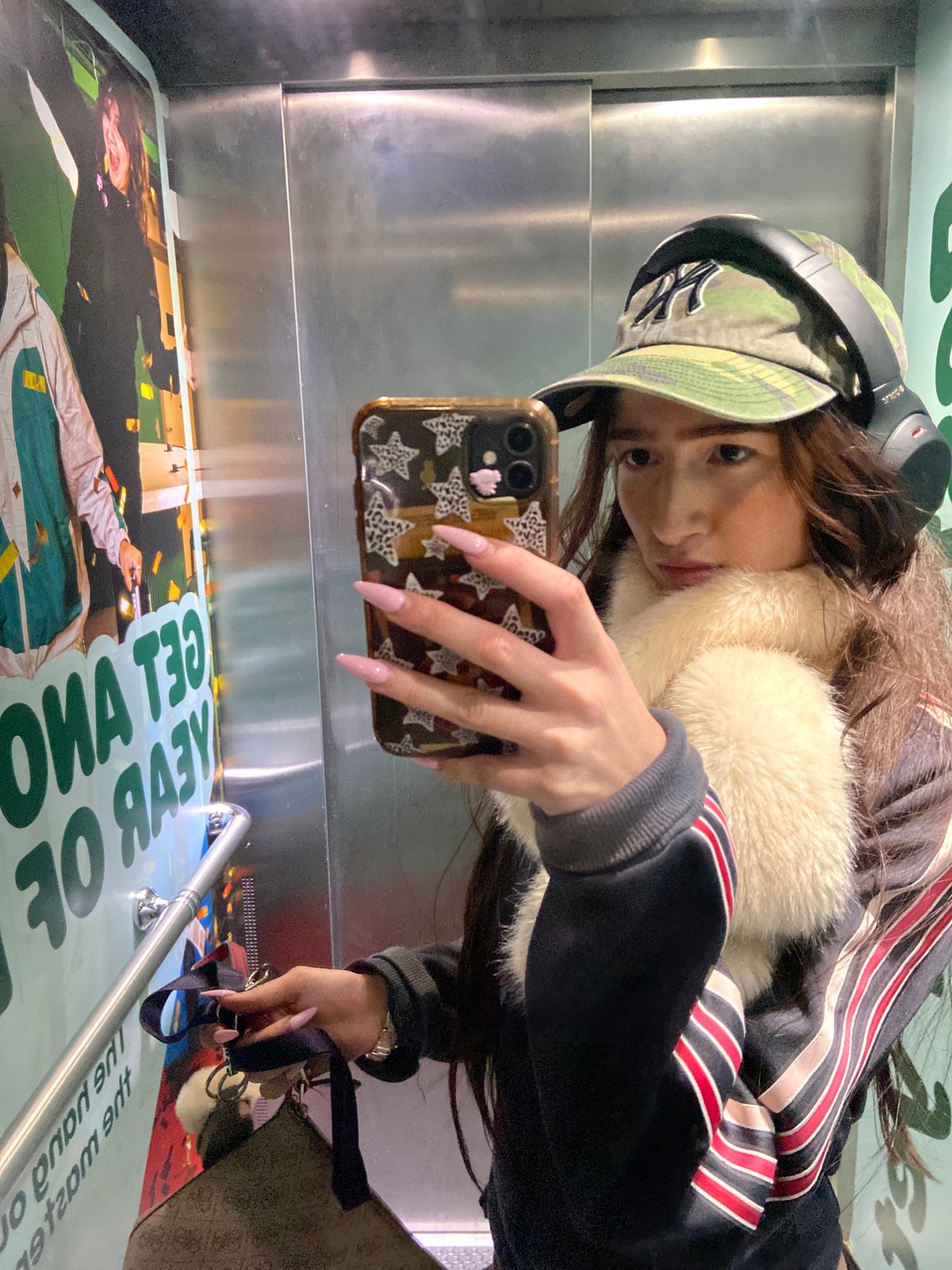 Woman takes selfie in London elevator wearing Yankees cap
