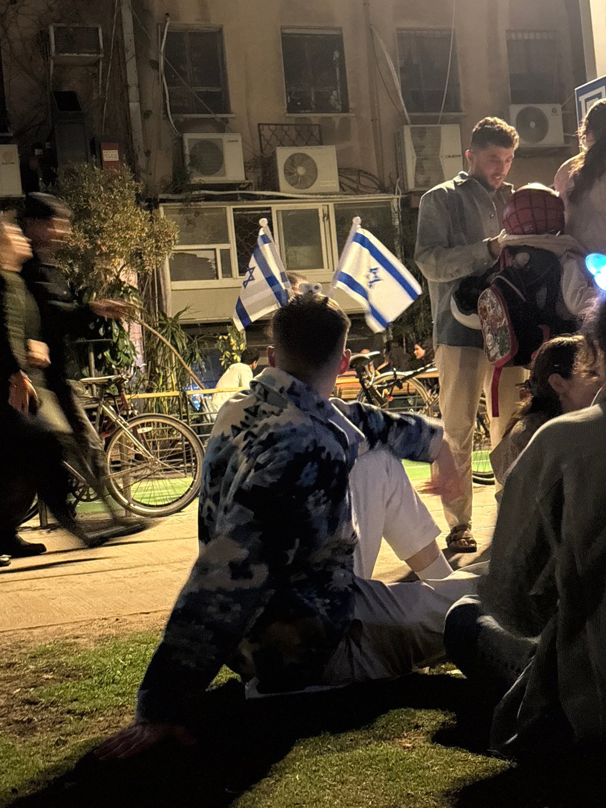 Group holds Israeli flags near Tel Aviv building Monday evening