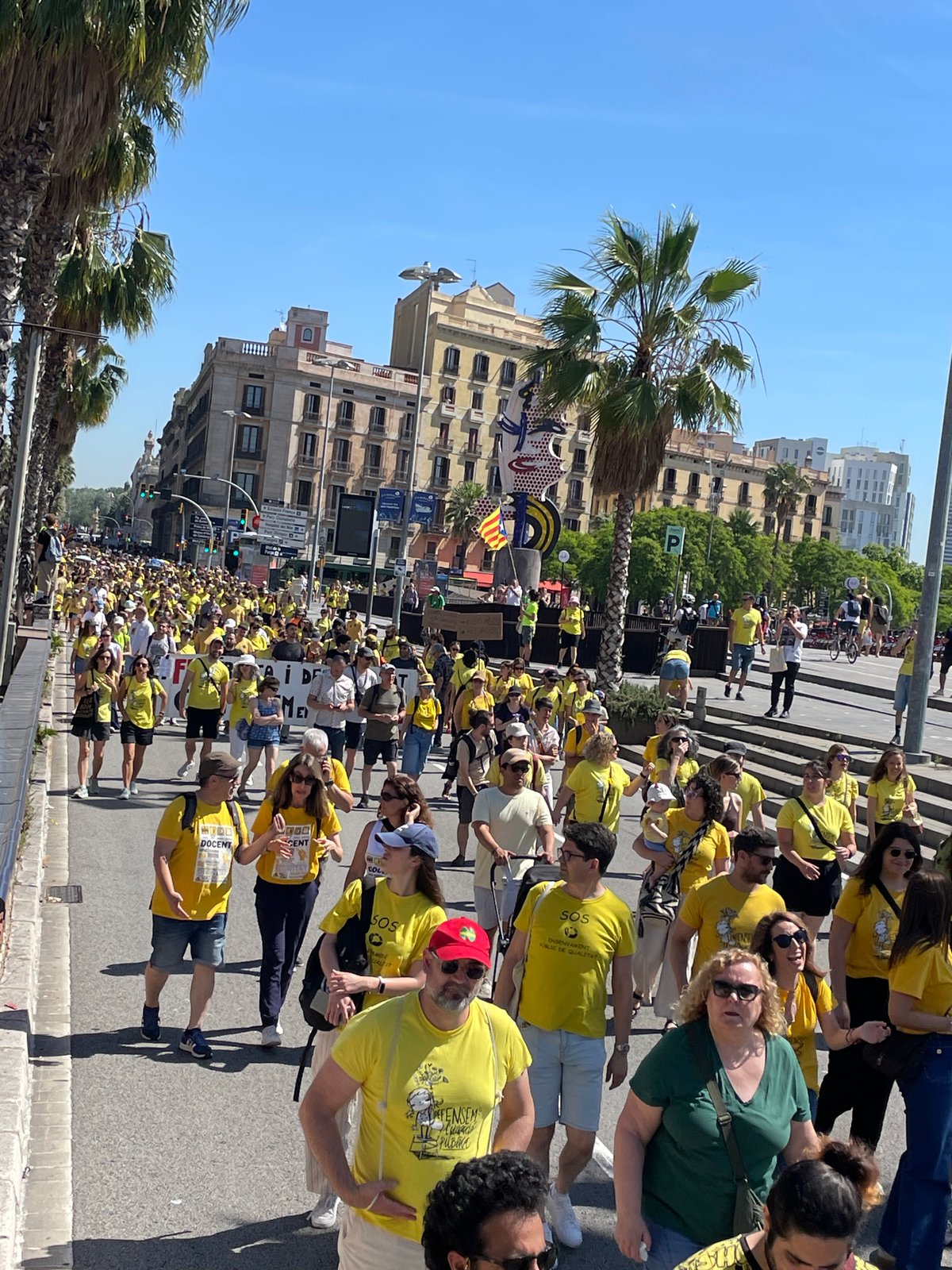 Yellow-shirted demonstrators march through Barcelona streets carrying flags