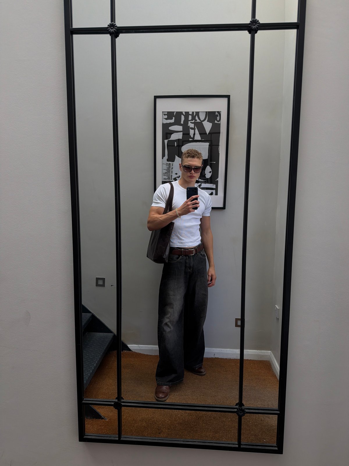 Mirror selfie with a bold black-framed multi-panel backdrop