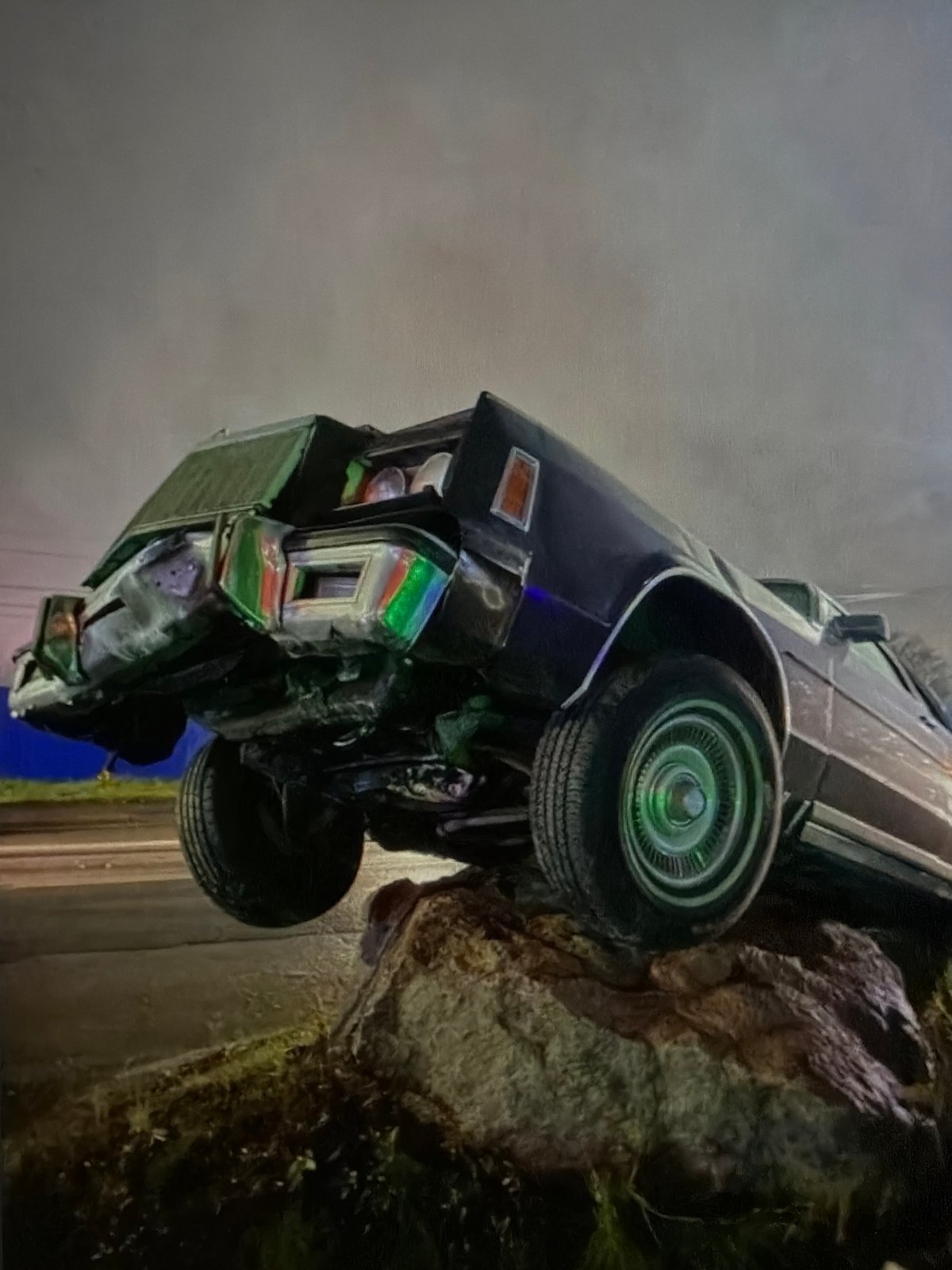 Vintage car found overturned against roadside embankment