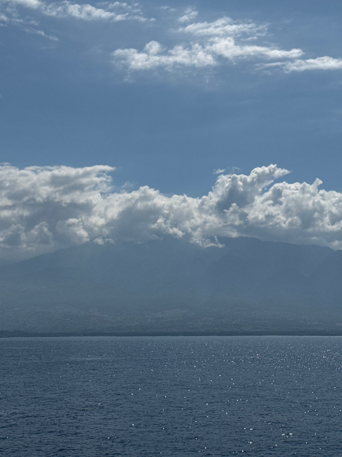 Ferry crossing Indonesian waters with mountains on the horizon