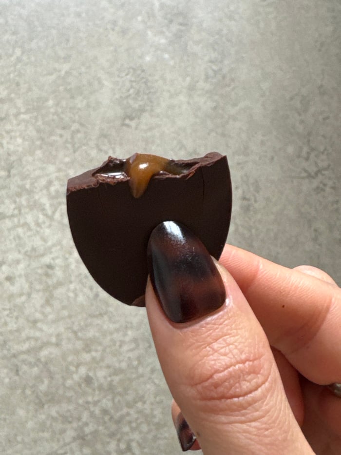 Person enjoys chocolate bonbon in Paris afternoon