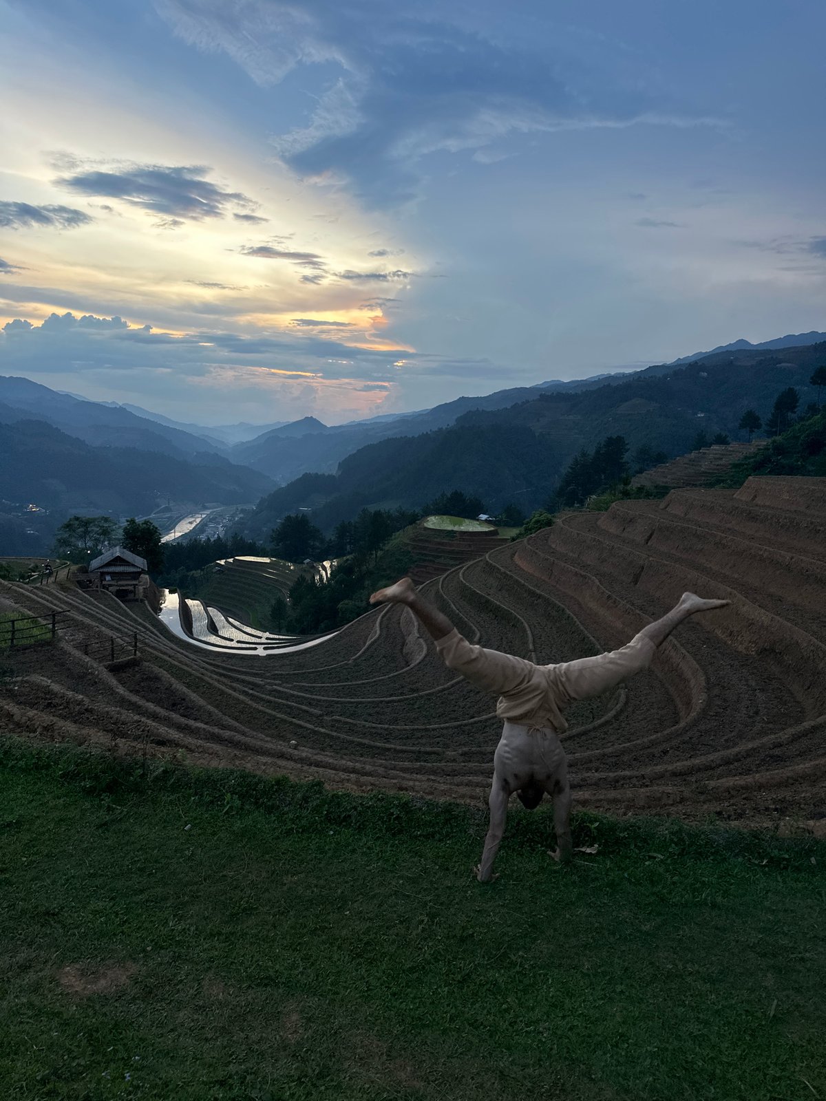 Tourist poses at Vietnam's terraced rice fields during twilight