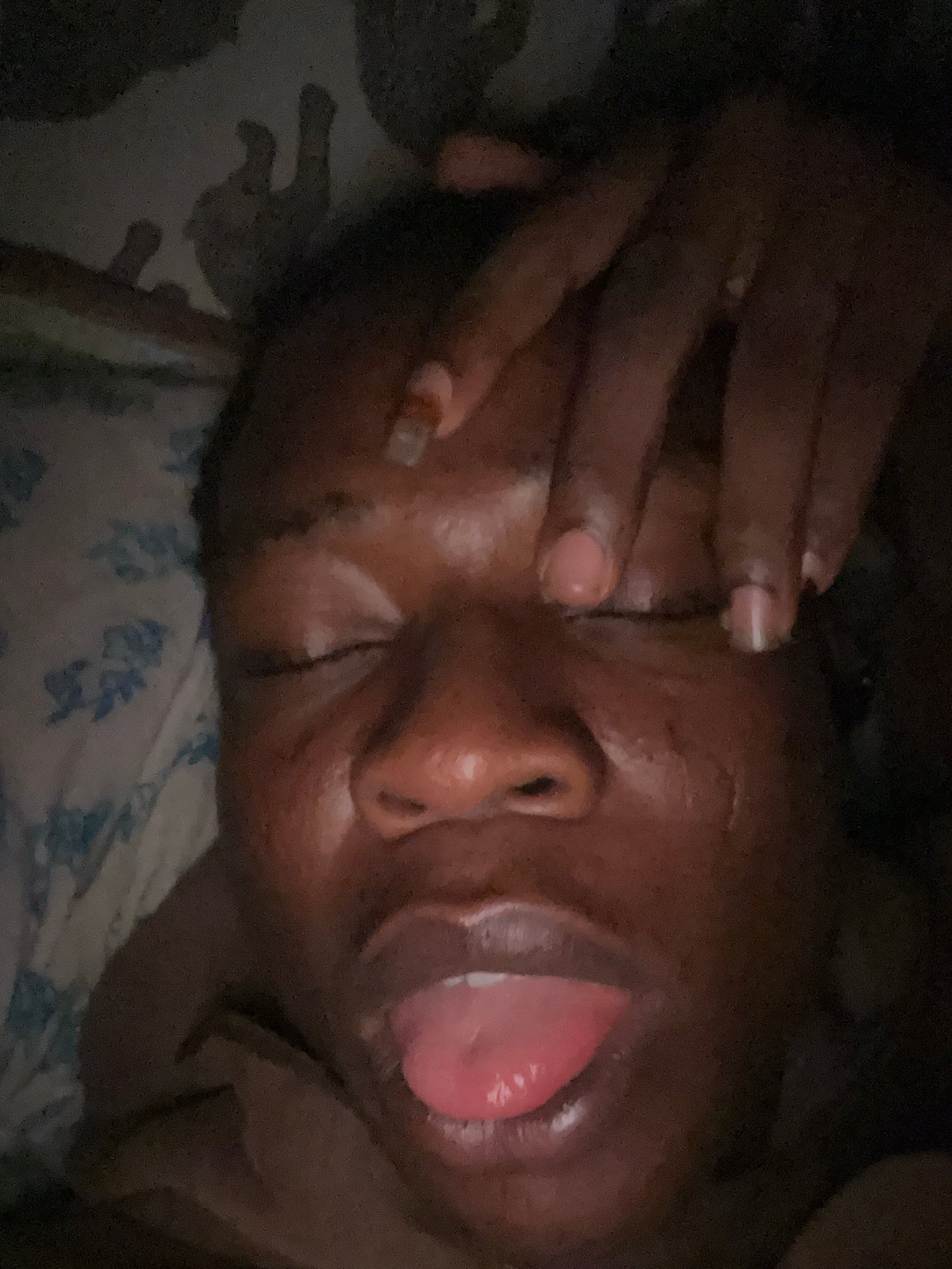 Person photographed in bed making facial expressions