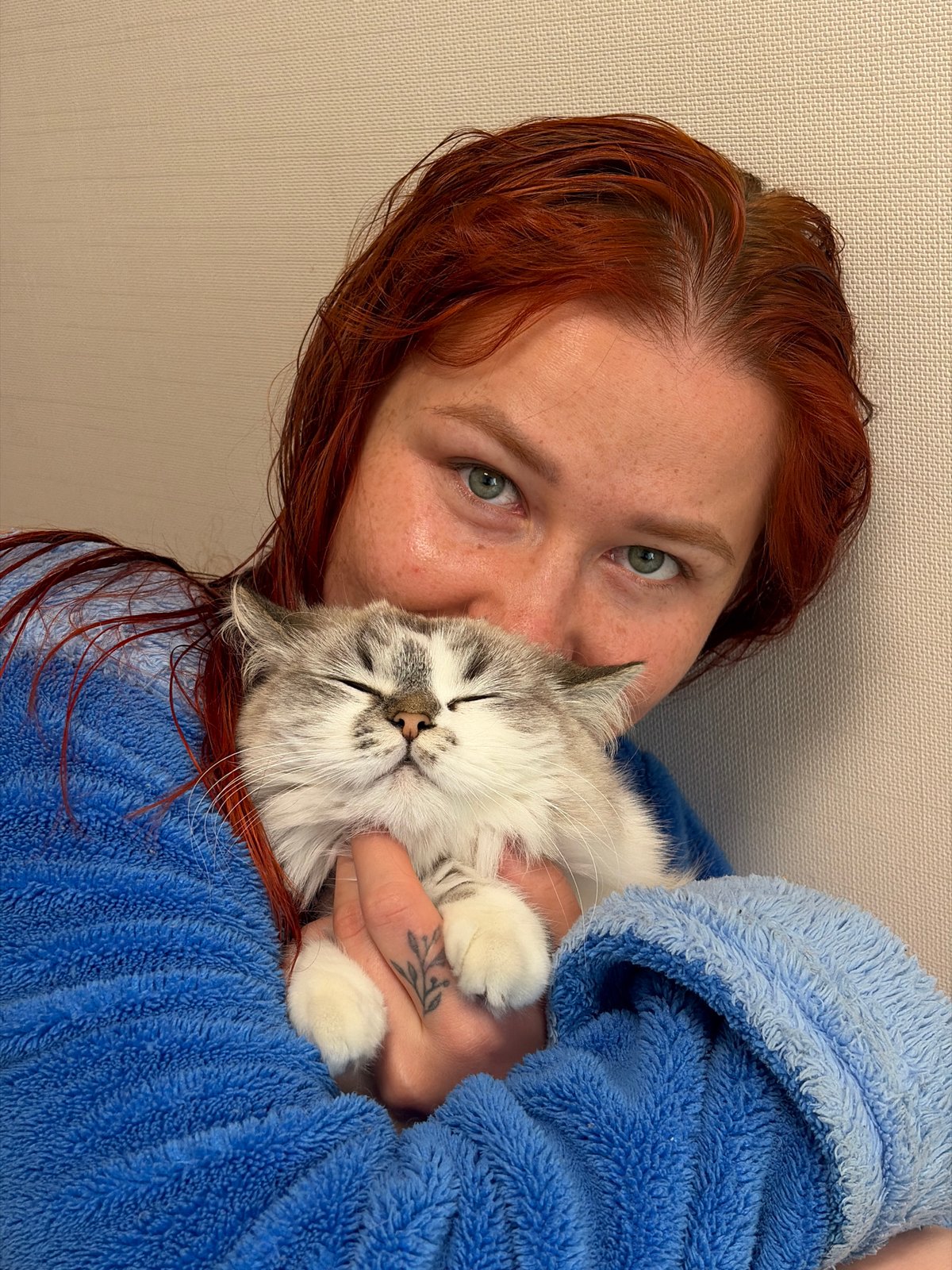 Woman in blue robe cuddles sleeping kitten in Rostov-on-Don