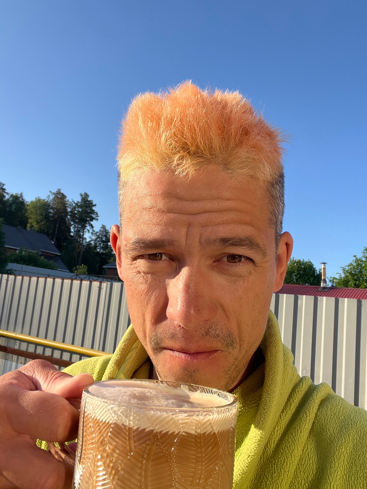 Man drinks outdoors in overgrown Chaikovsky area early morning