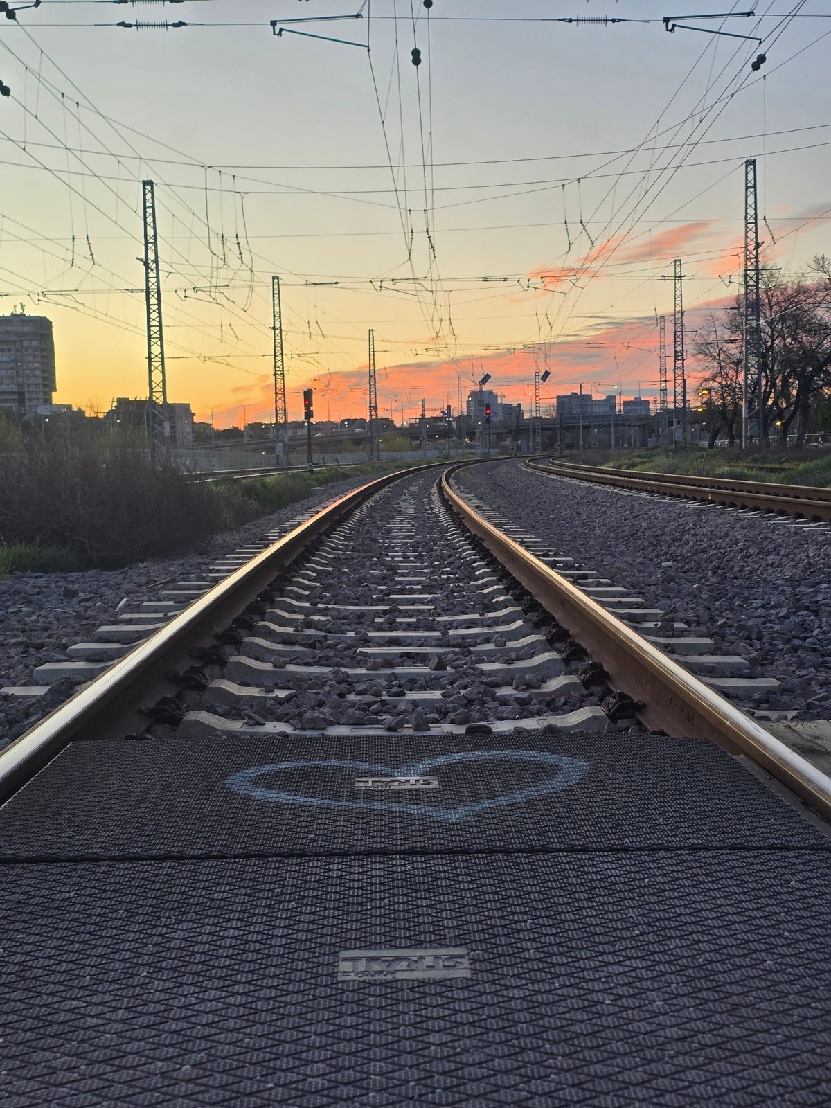 Train approaches through urban Plovdiv at dawn