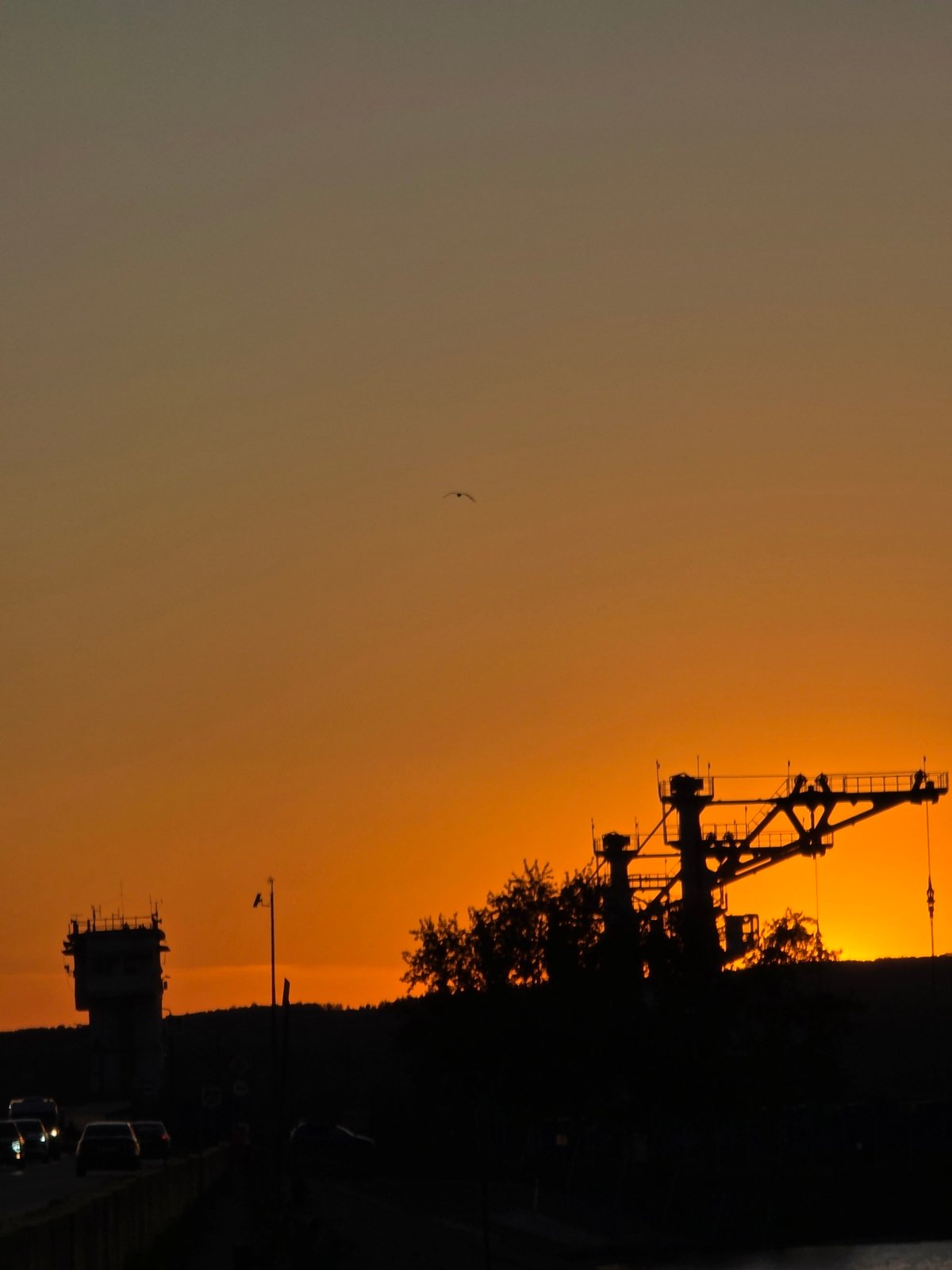 Industrial cranes and open water meet a Kama River sunset