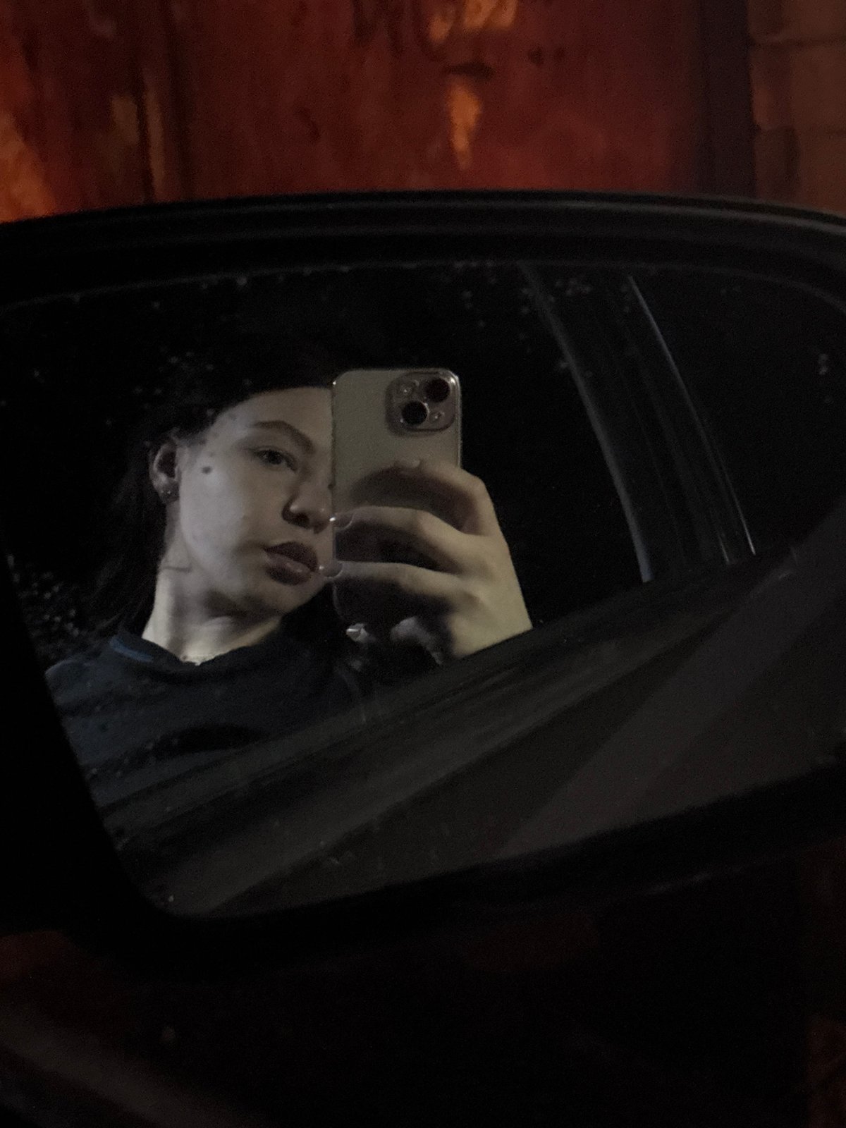 Person takes iPhone selfie reflected in side mirror in Perm