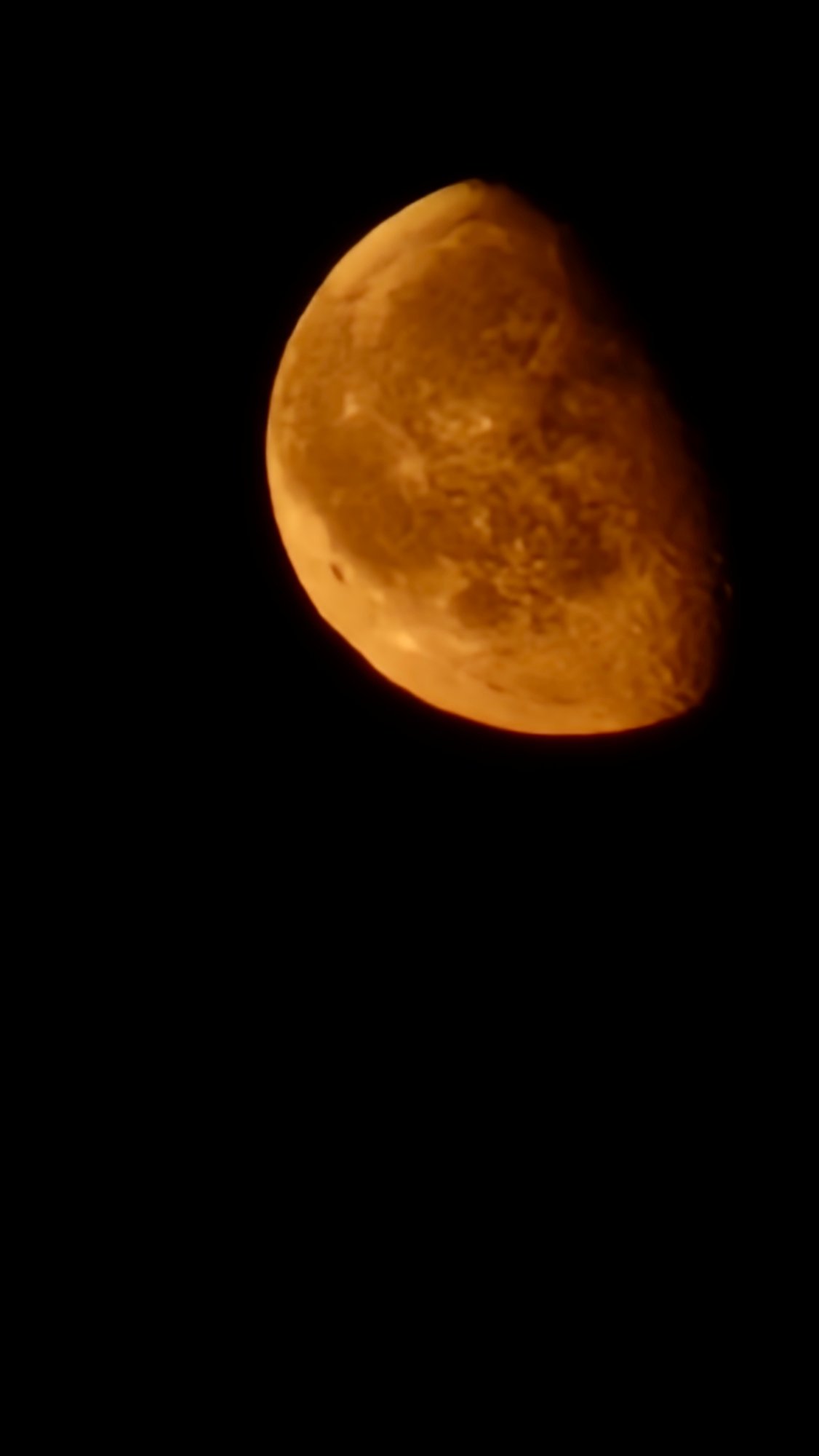 Crescent moon glows orange over Krasnodar night sky