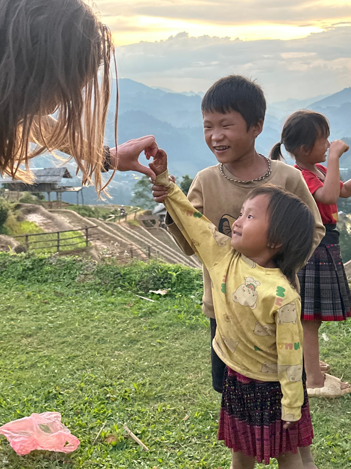 Families play among Vietnam's terraced rice fields during golden hour