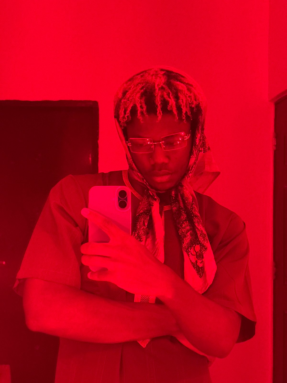 Person takes red-lit selfies indoors in Igboefon, Nigeria