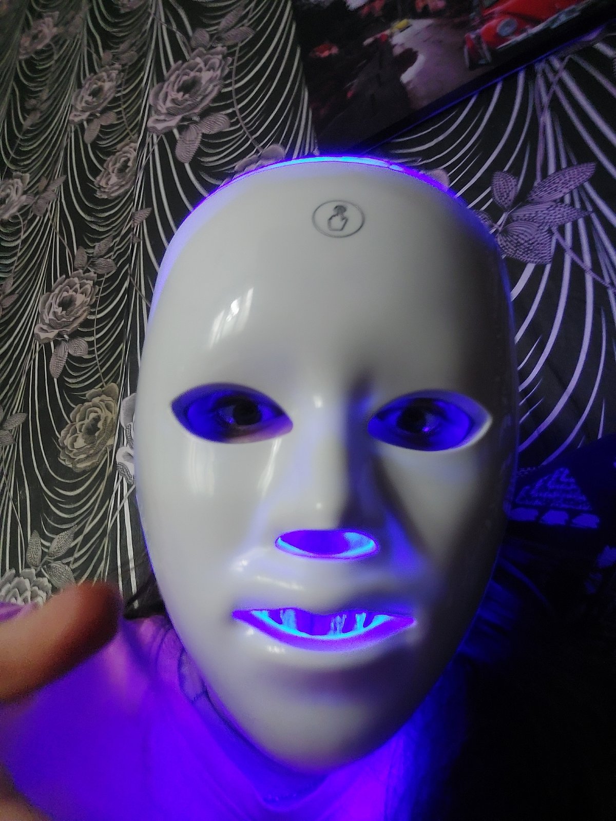 Illuminated humanoid mask observed with blue purple internal lighting