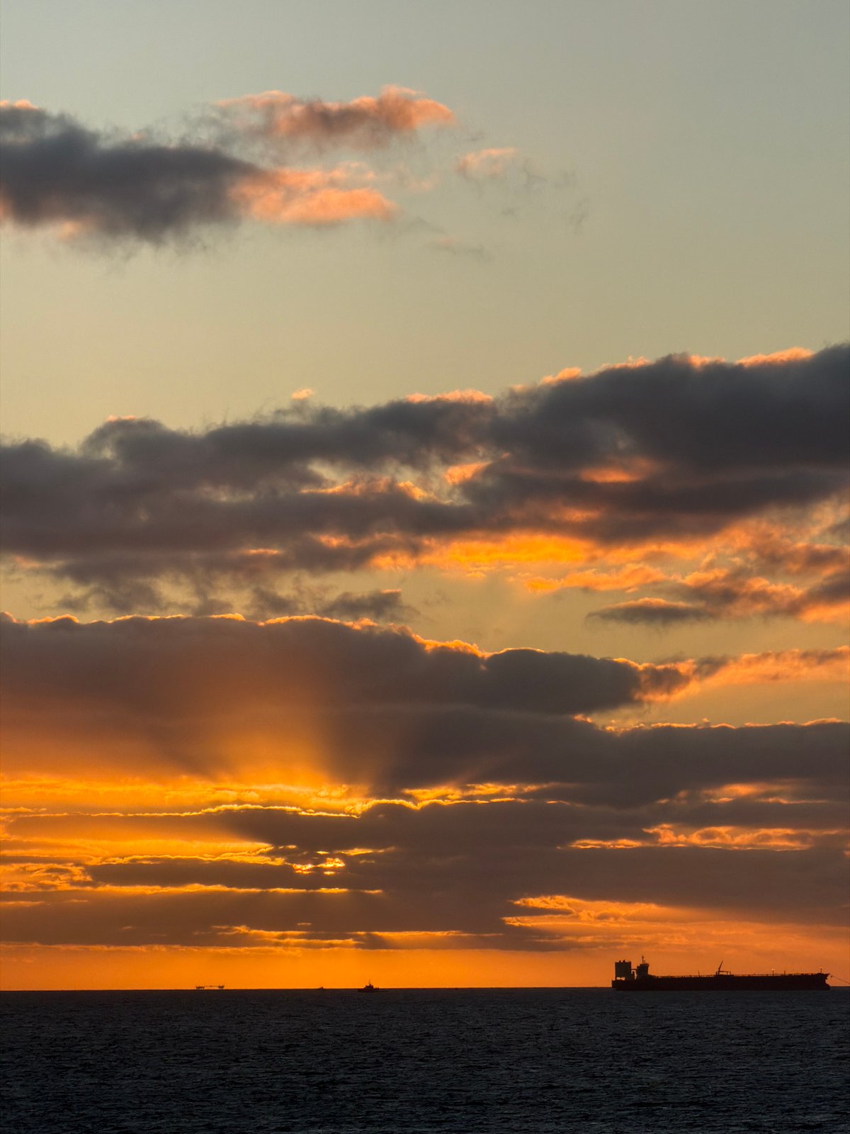 Ocean sunset with ship silhouette captured by witnesses