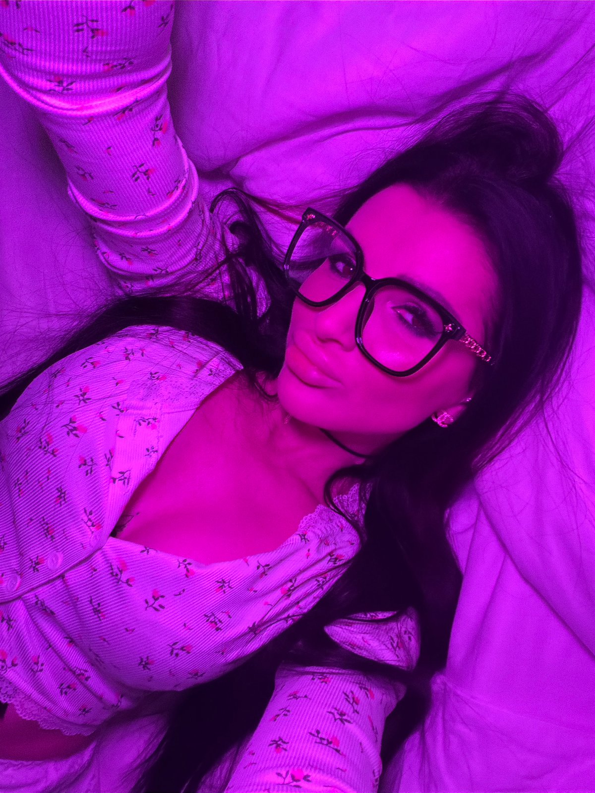 Woman takes selfies in purple-lit bedroom in Voronezh