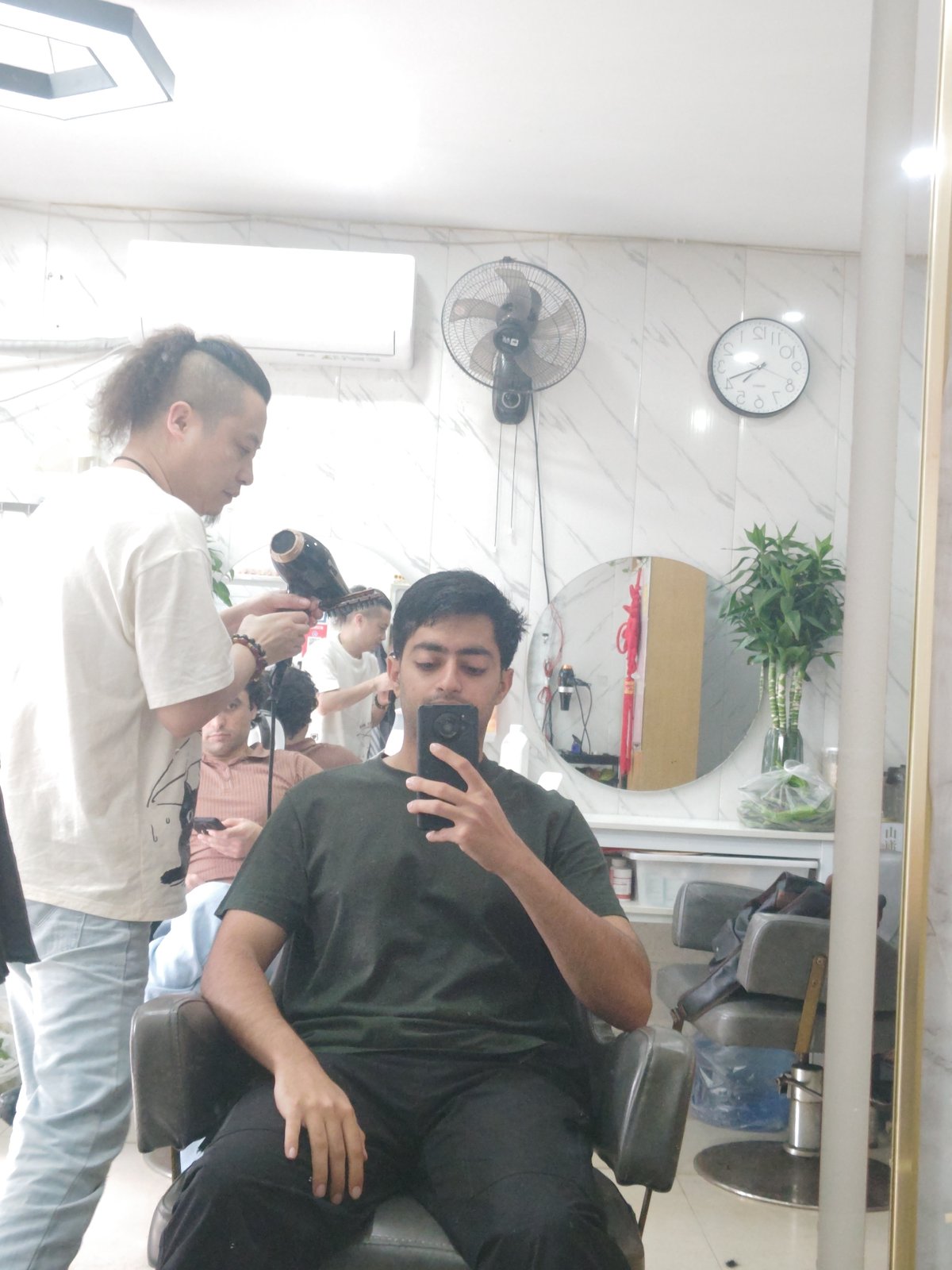 Young man gets haircut at Chongqing barbershop