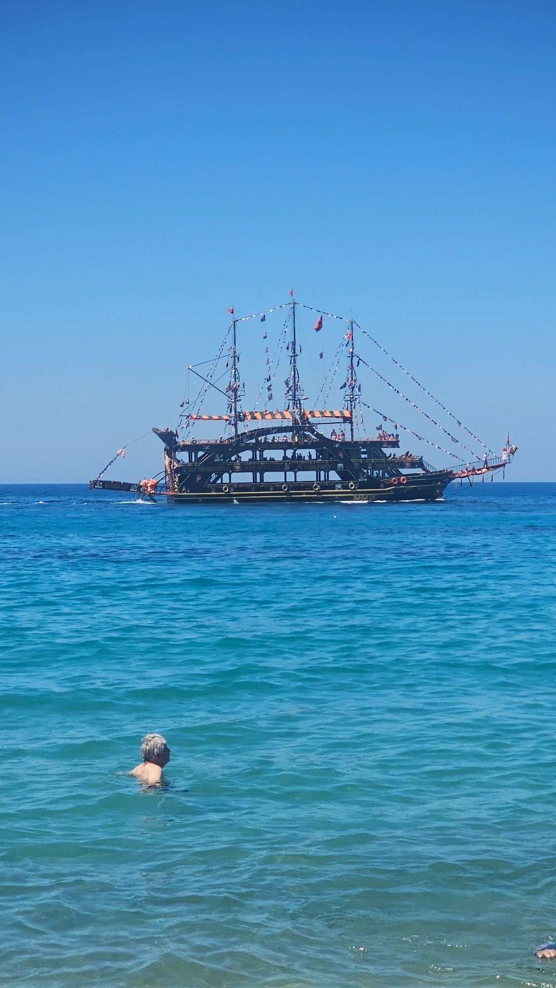 Alanya beach in full summer swing, pirate boat included.