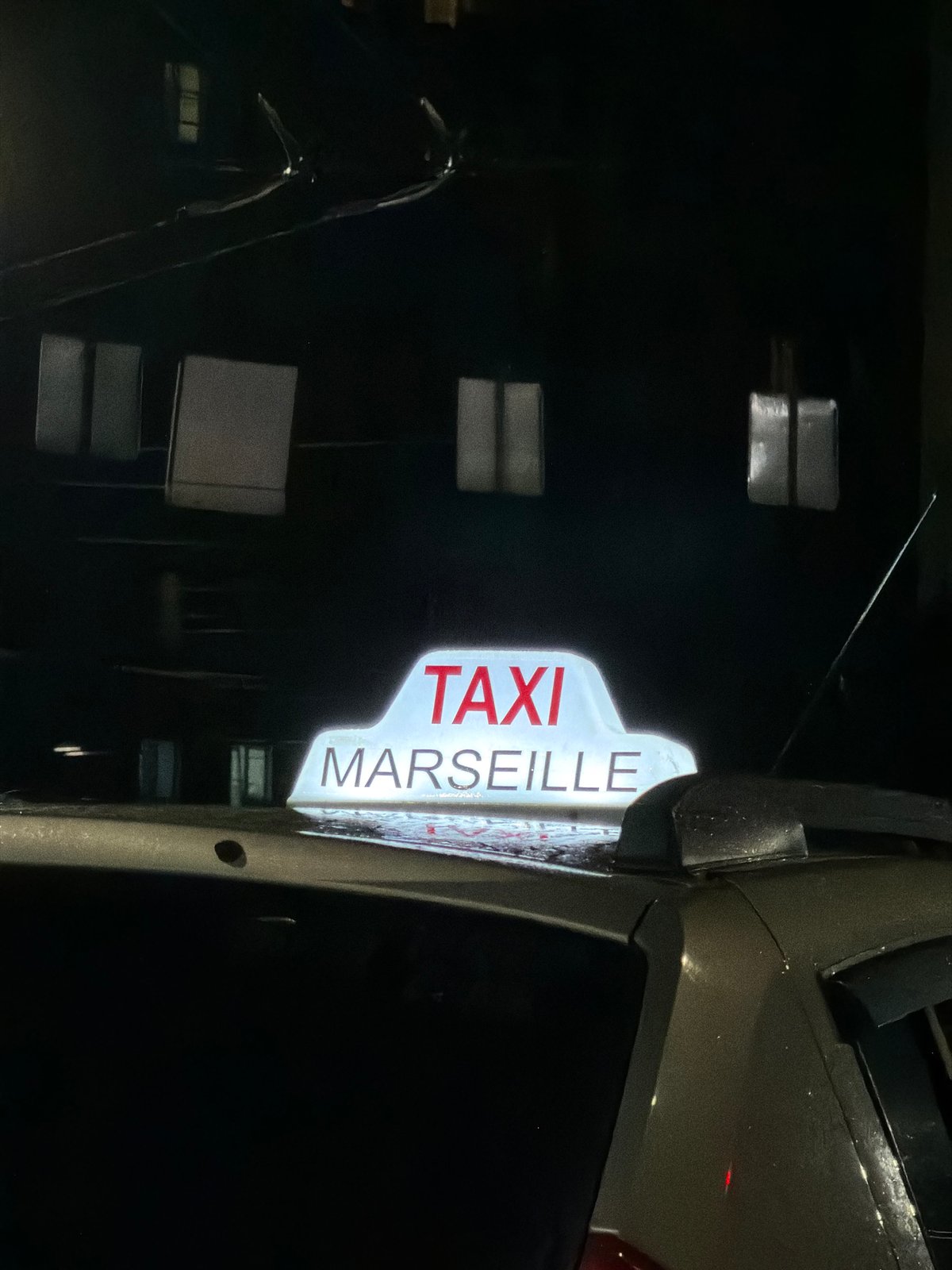 Illuminated taxi sign outside a building in Izhevsk at night
