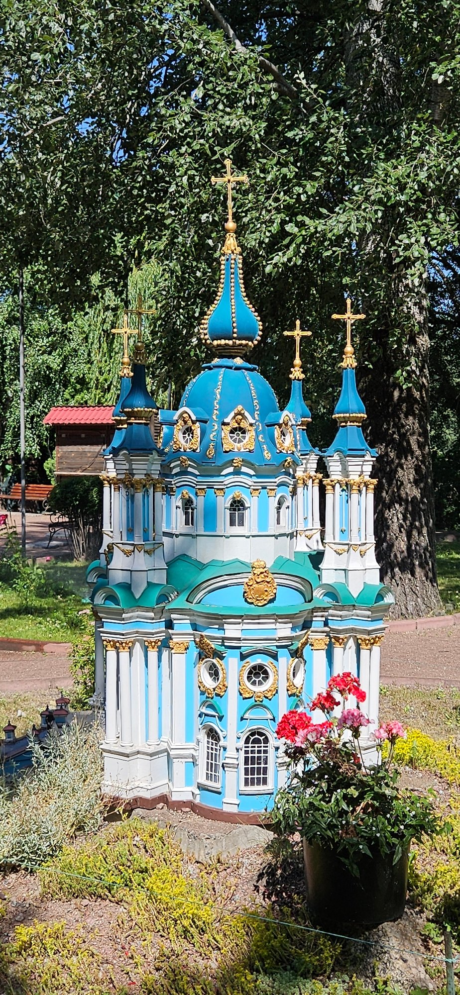 Miniature blue and white architectural models on display in a park