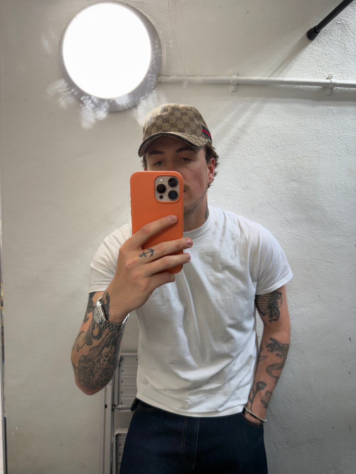 Man takes mirror selfie in London wearing patterned cap