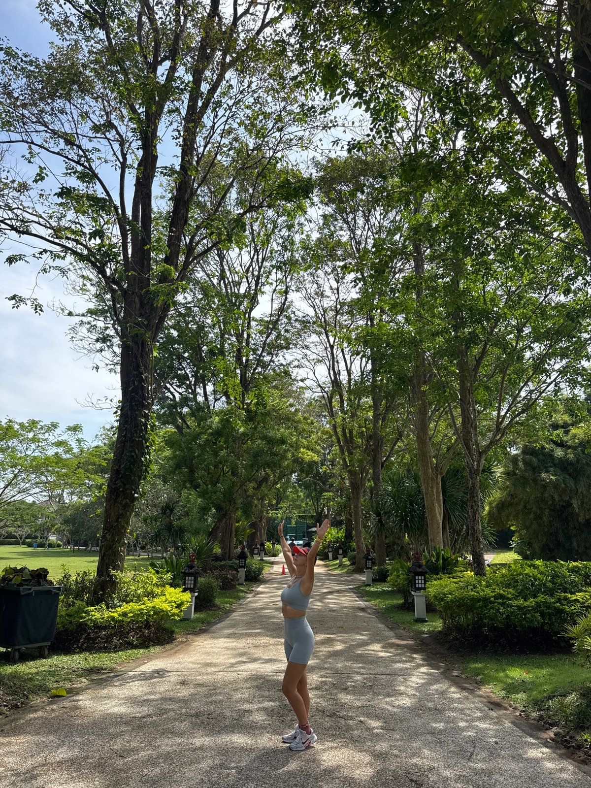 Groundskeeper maintains tropical lawn in early morning Kuta Selatan